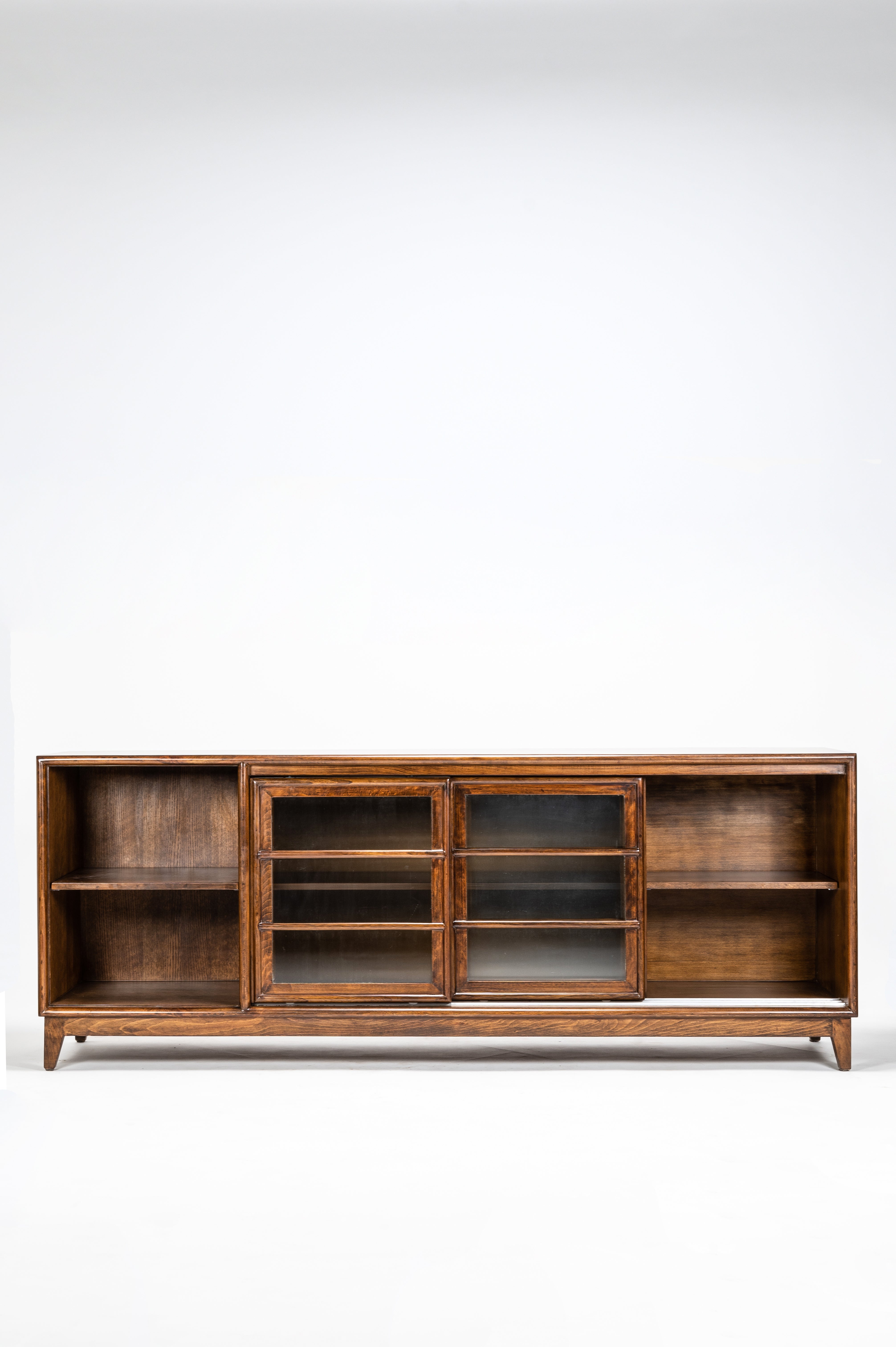 Wooden bookshelf with glass doors on a white background