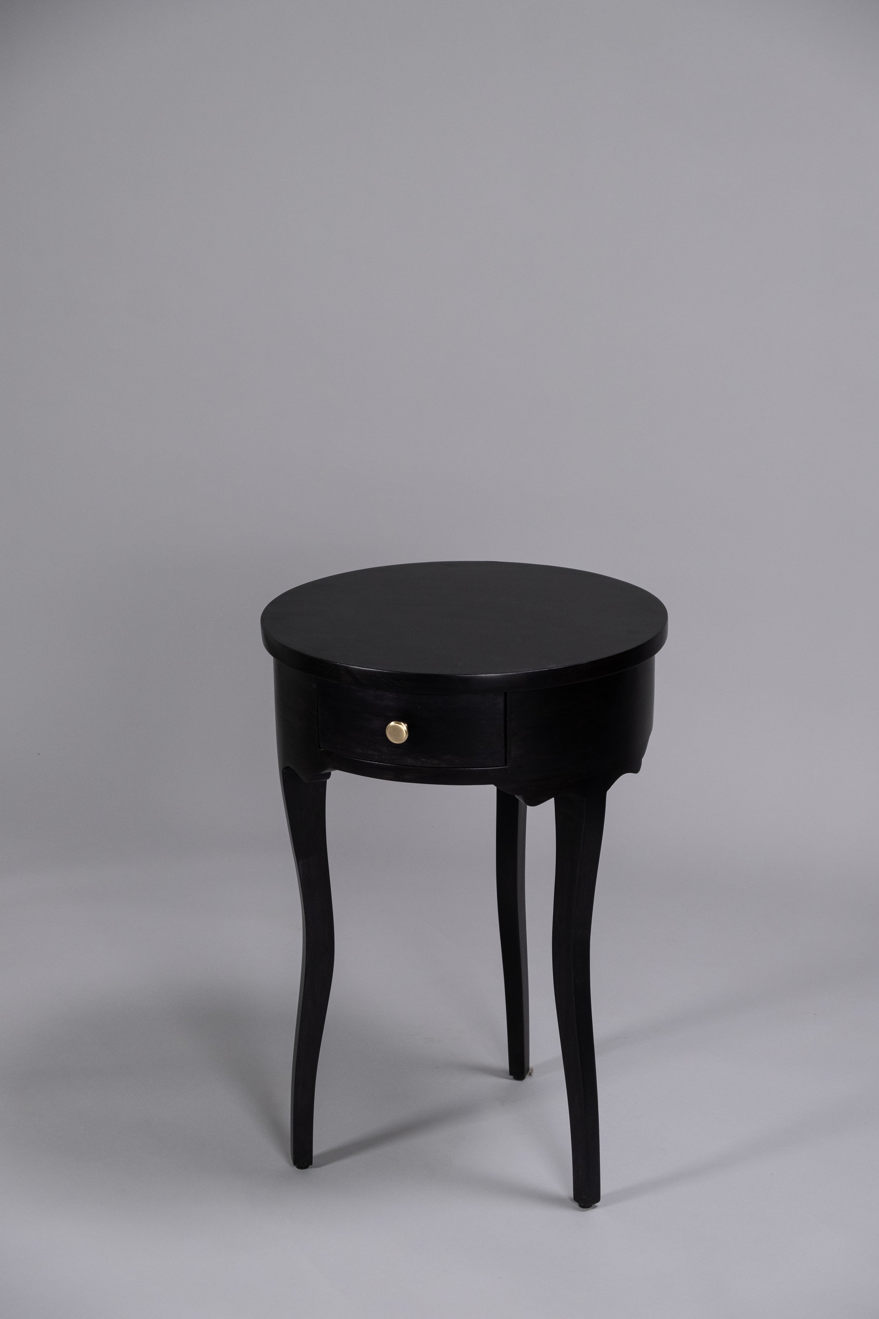 Black side table with a drawer on a gray background