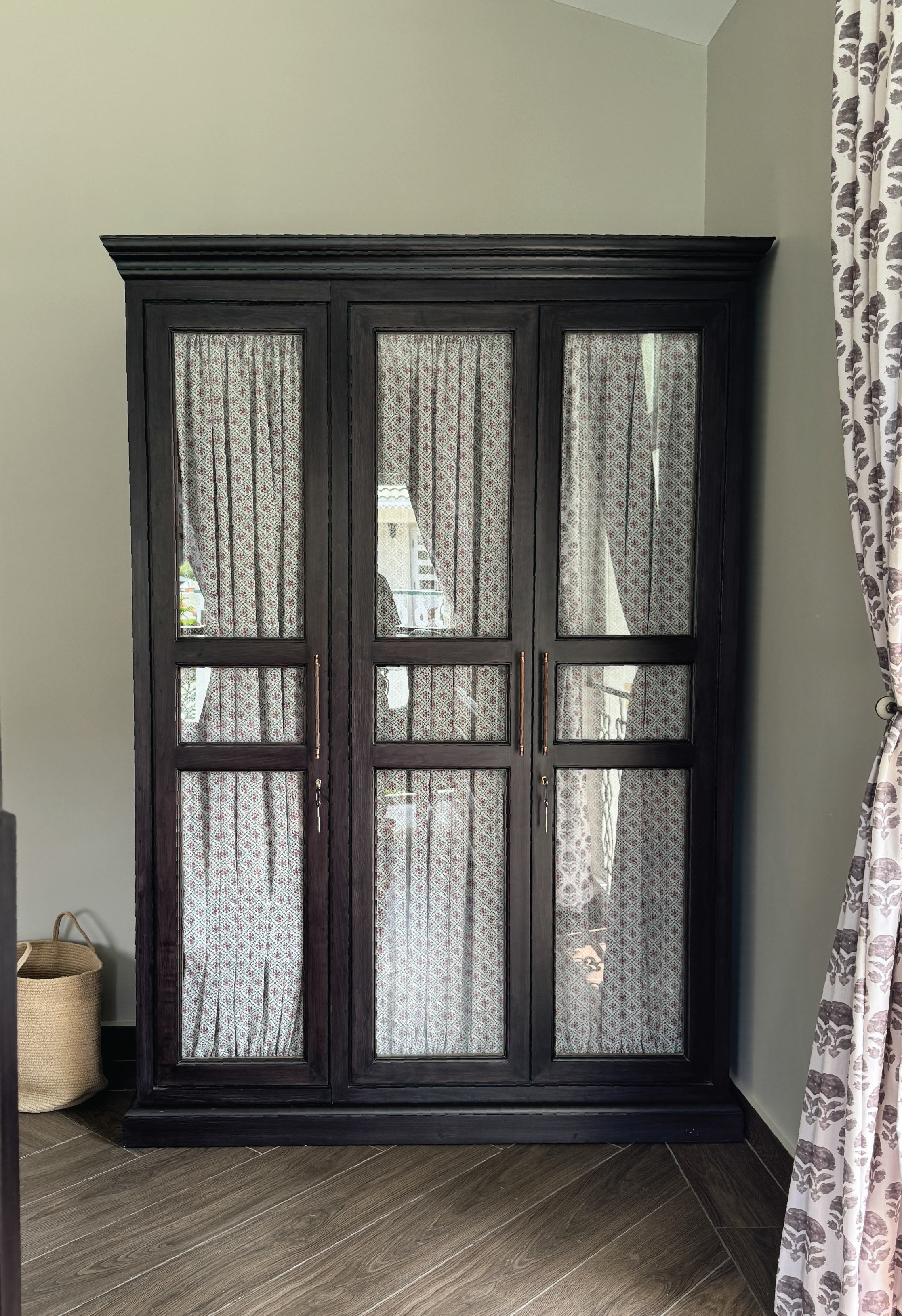 Dark wooden cabinet with glass panels in a room setting