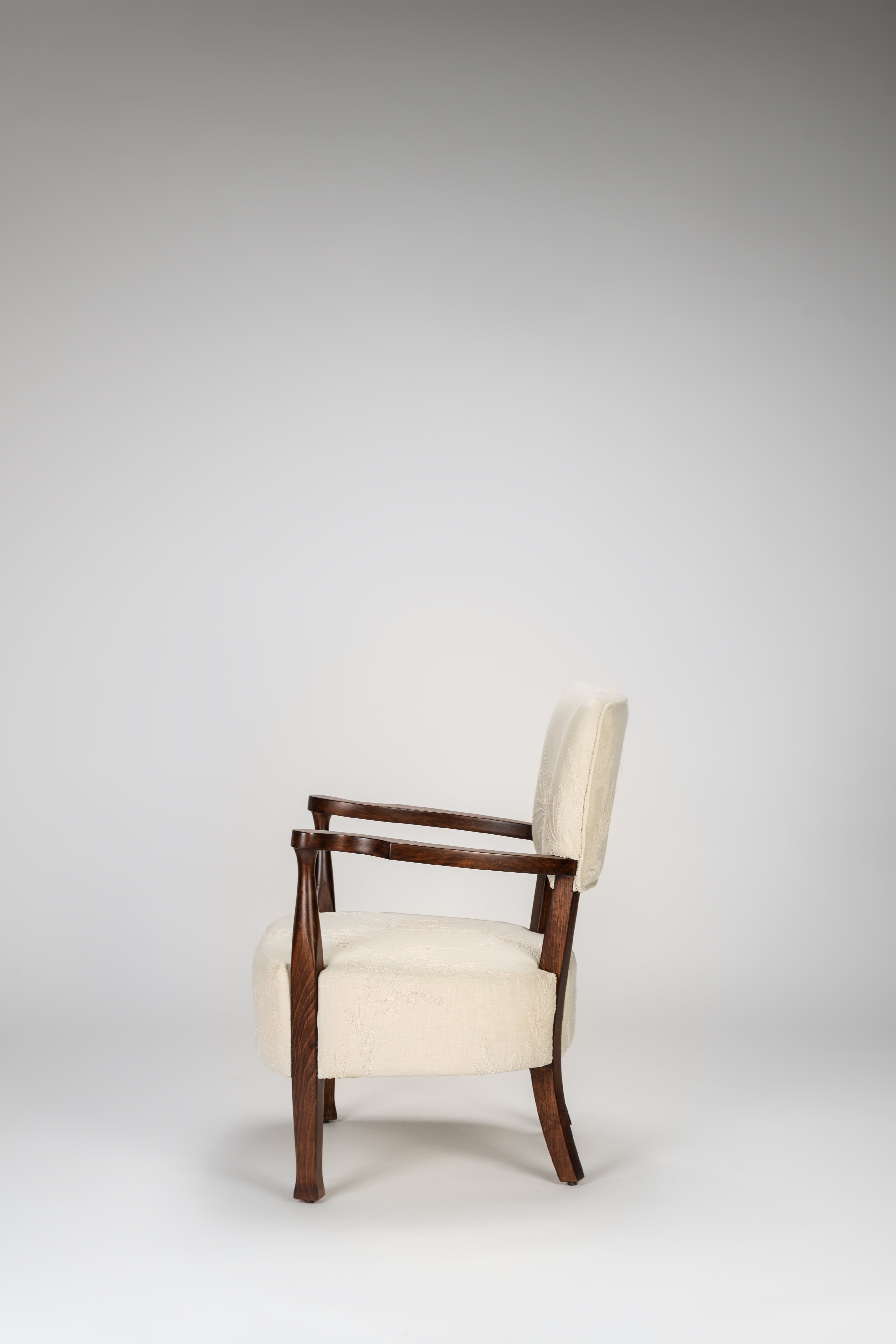 Chair with wooden frame and white cushion on a gray background