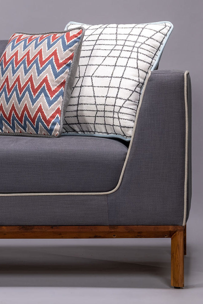 Gray sofa with two decorative pillows on a gray background
