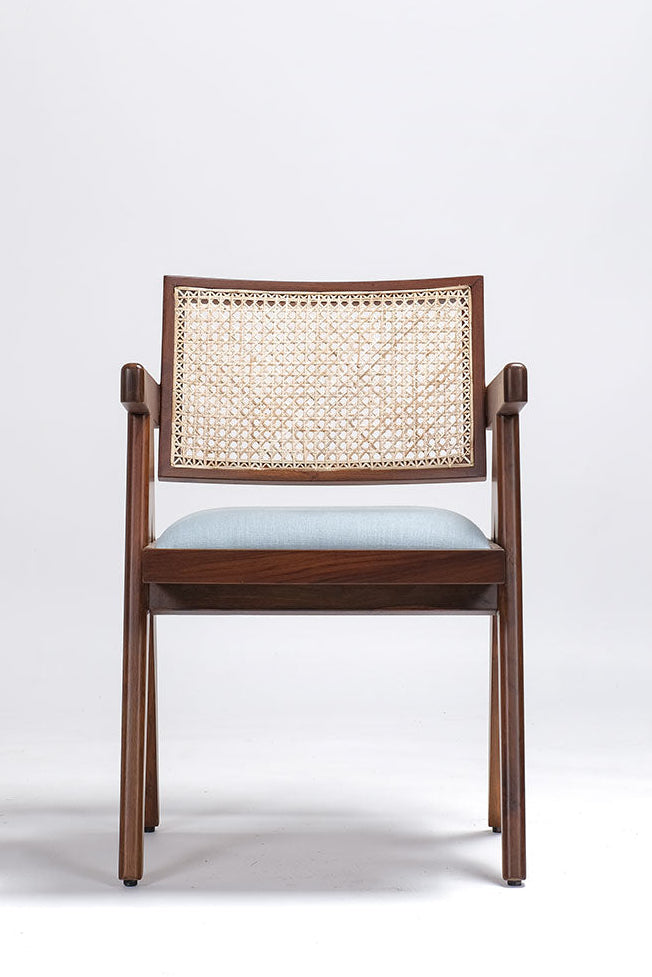 Wooden chair with wicker backrest and light blue cushion on a white background