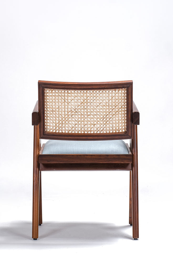Wooden chair with wicker backrest and light blue cushion on a white background