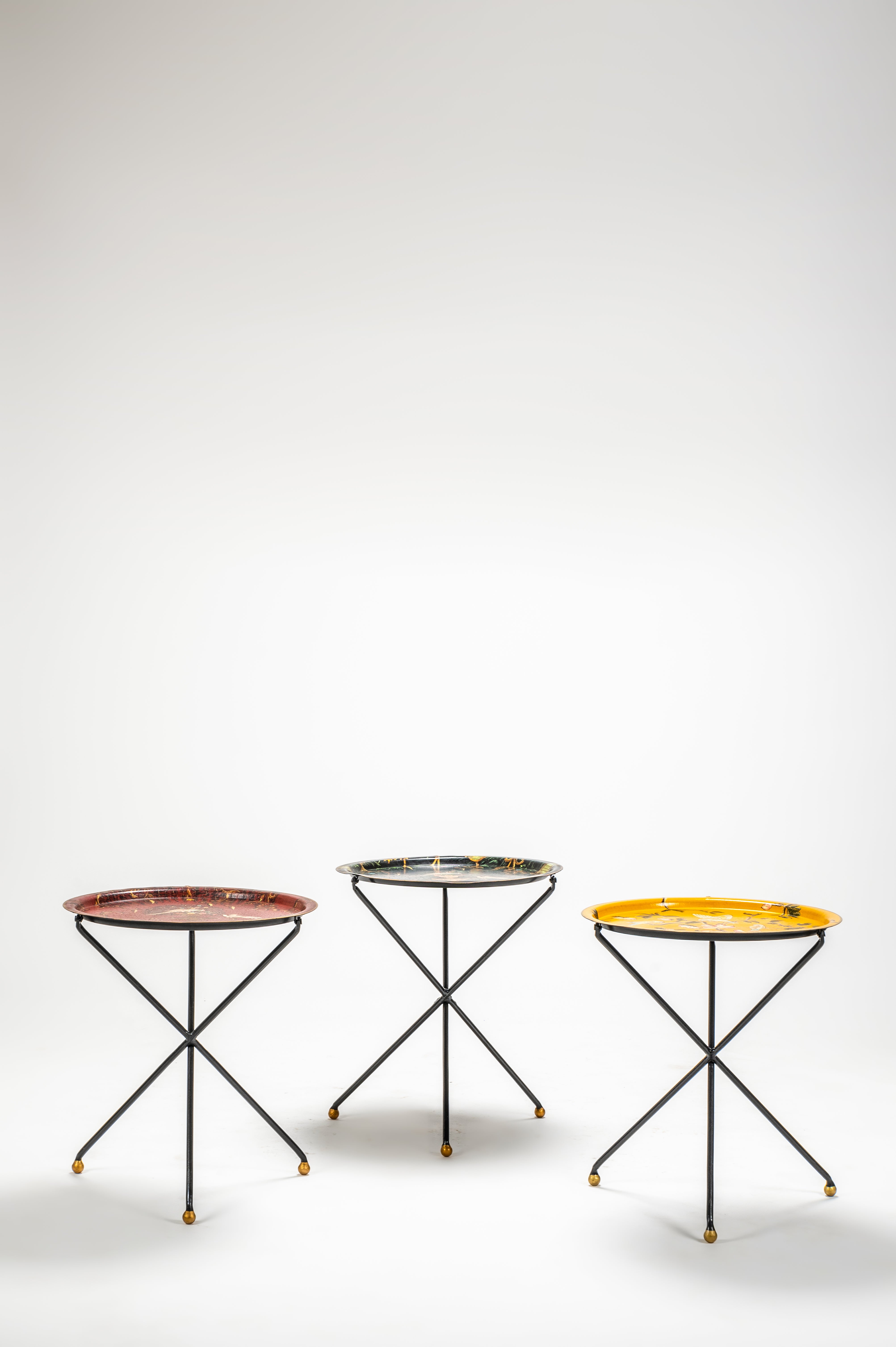 Three small round tables with metal legs on a white background