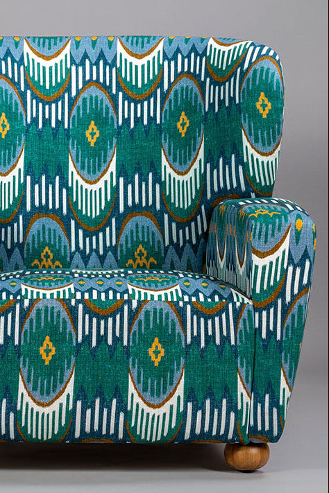 Patterned armchair with teal and brown design on a gray background
