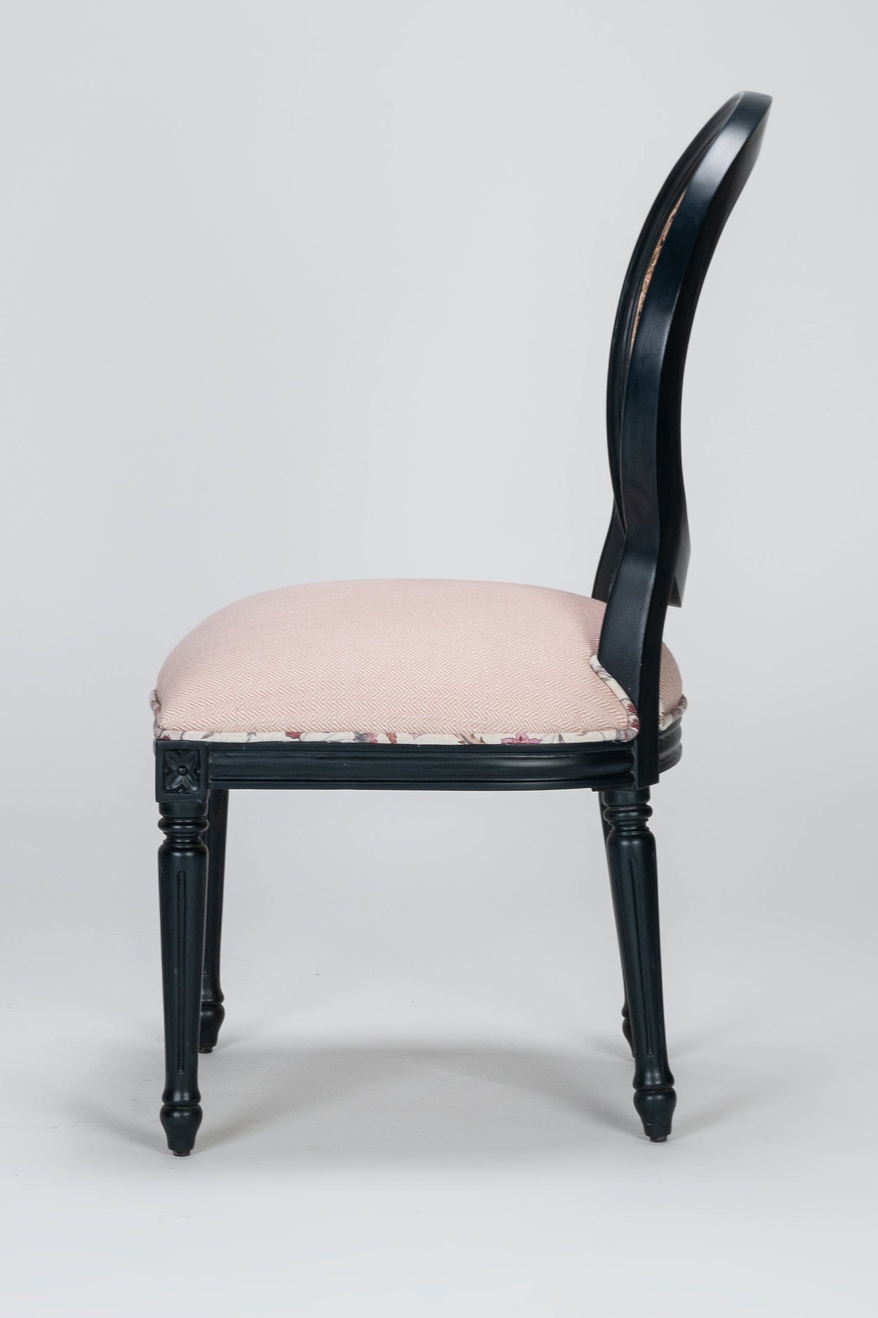 Chair with black frame and pink cushion on a gray background