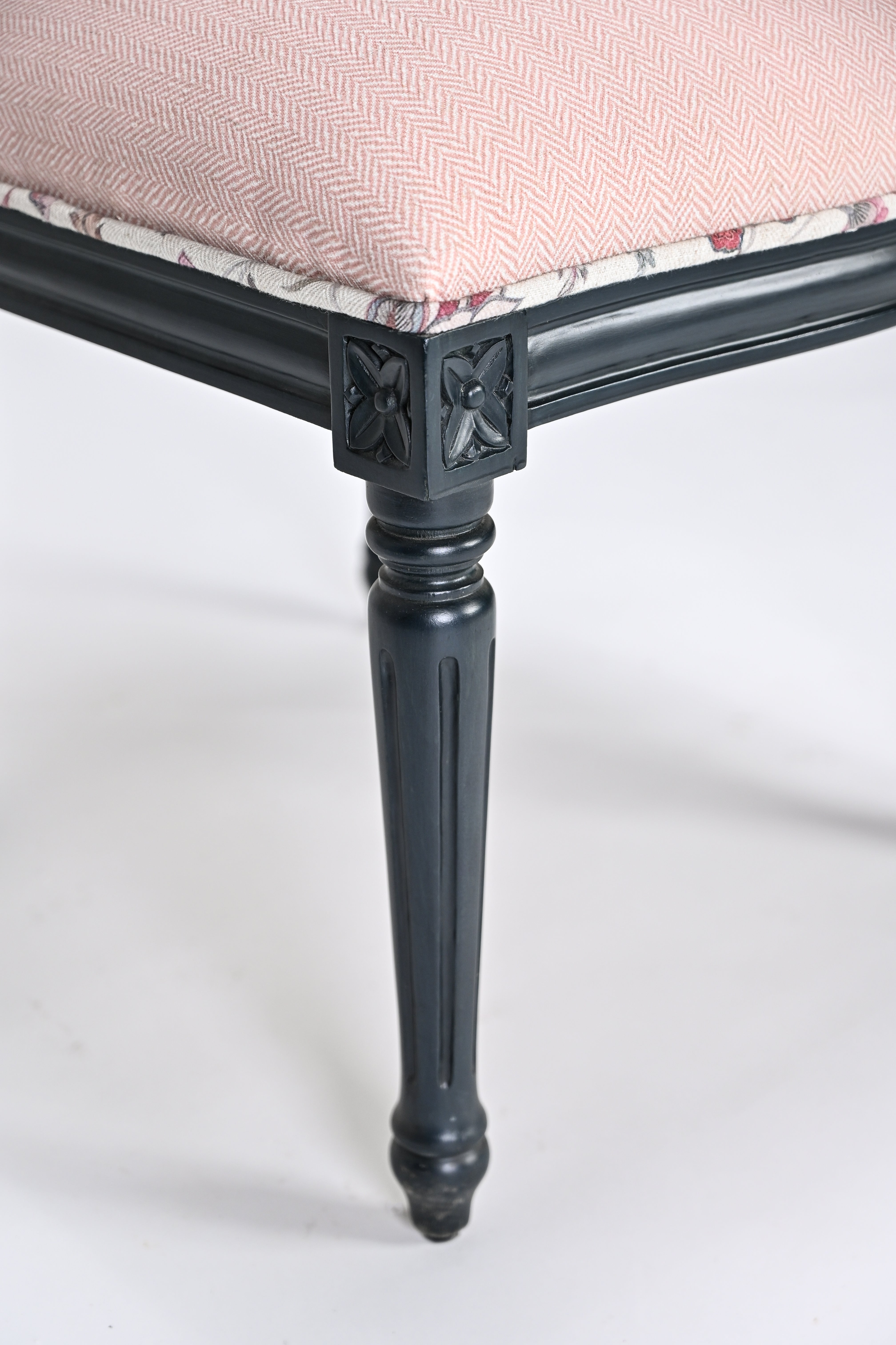 Chair with black legs and pink cushion on a white background