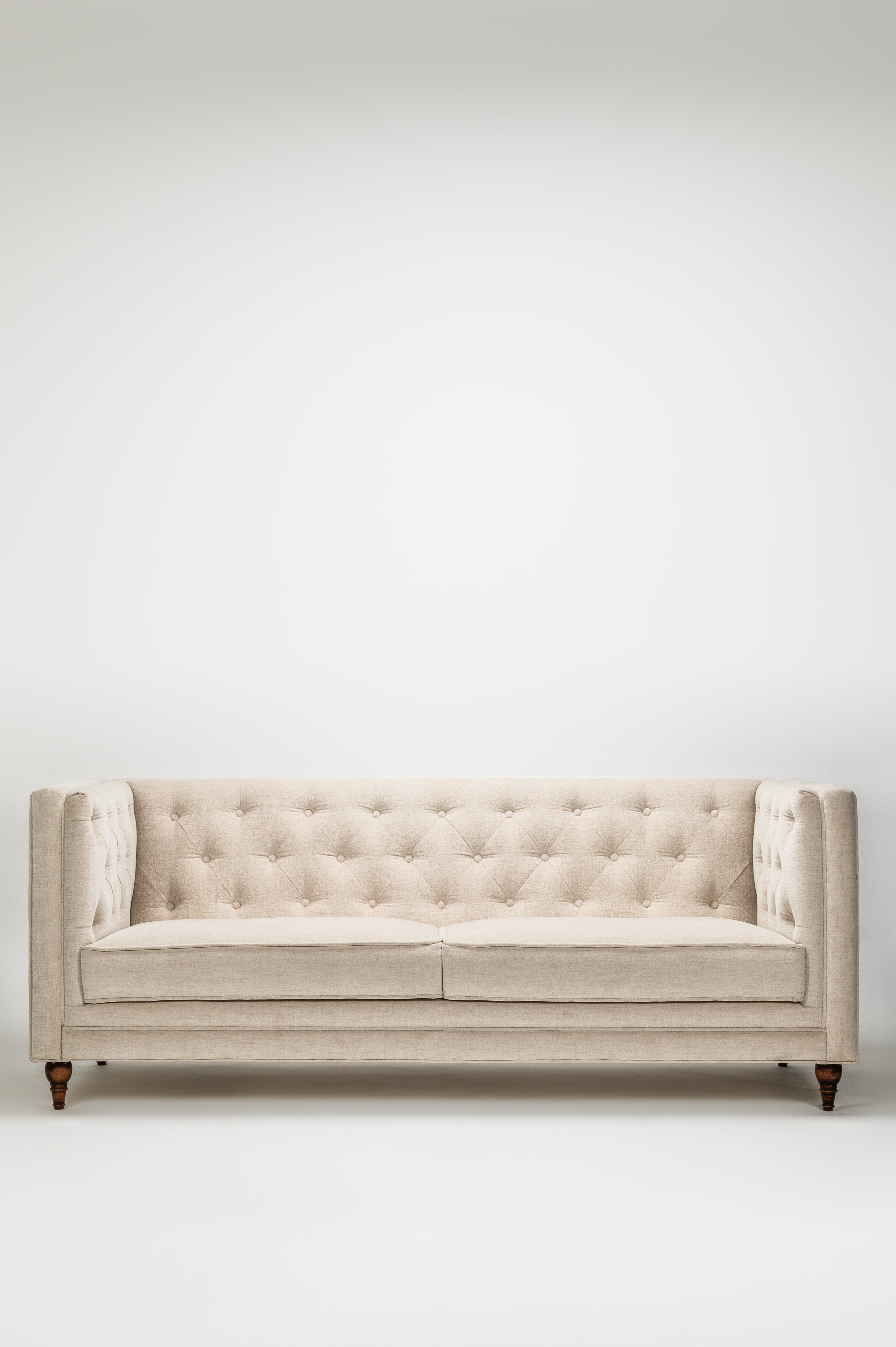 Beige tufted sofa on a white background