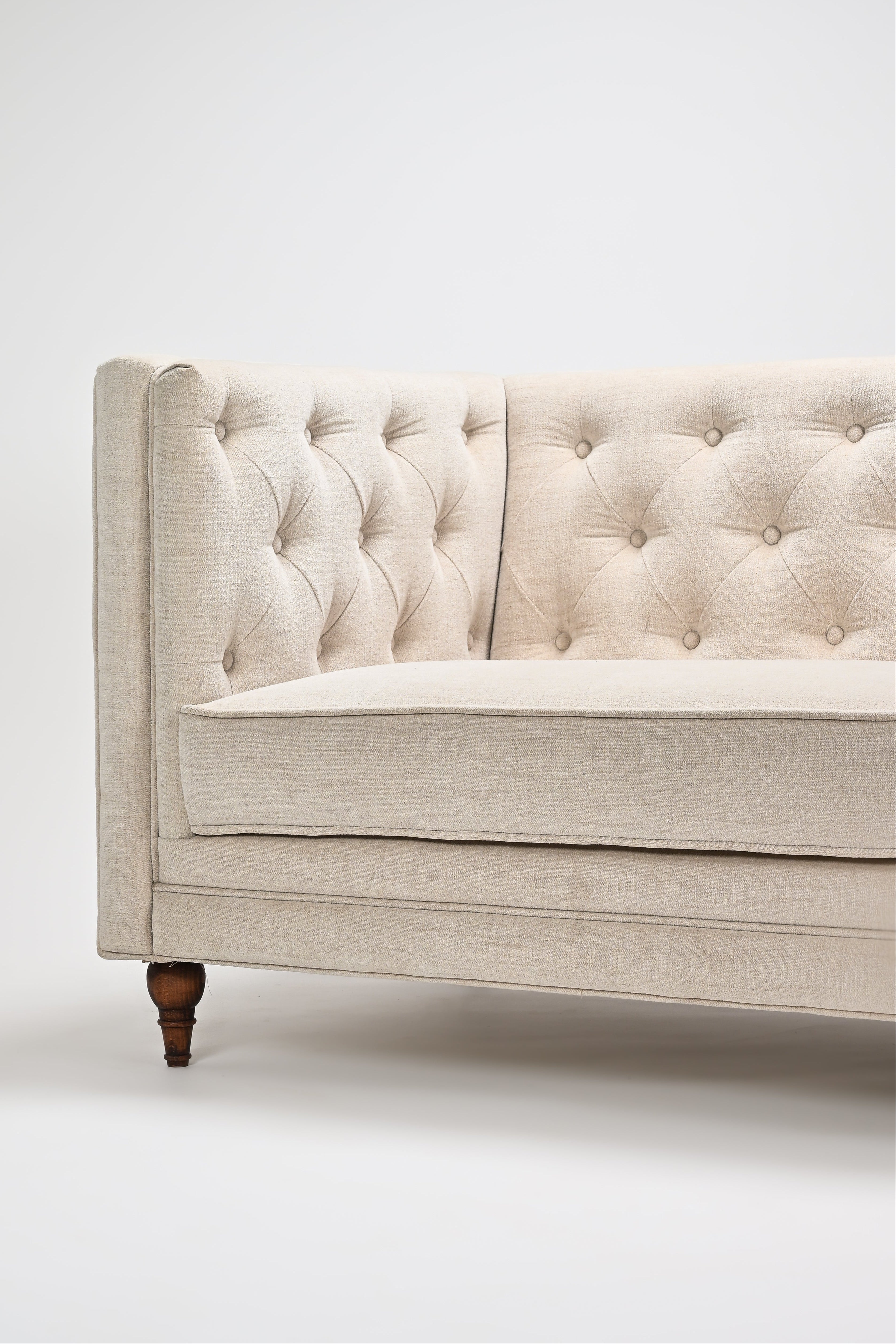 Beige tufted sofa on a white background