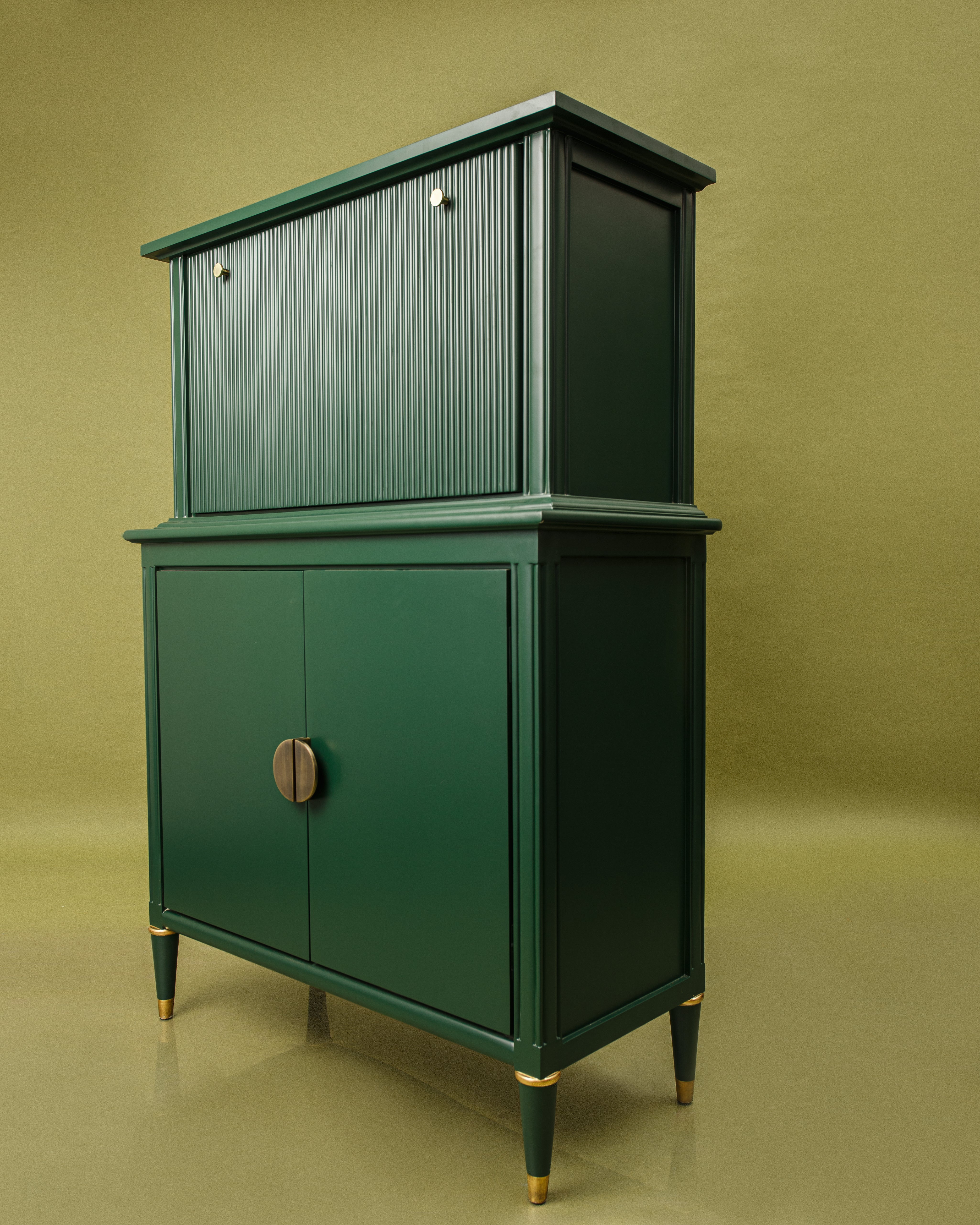 Green cabinet with gold accents on a matching green background