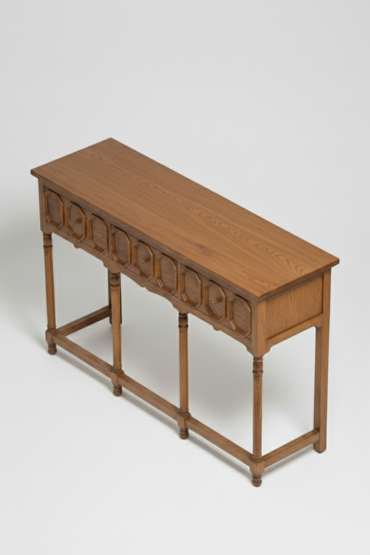 Wooden console table with decorative carvings on a white background