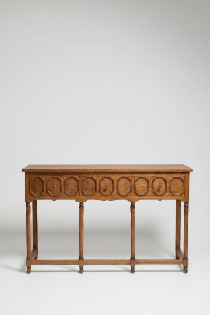 Wooden console table with decorative carvings on a white background