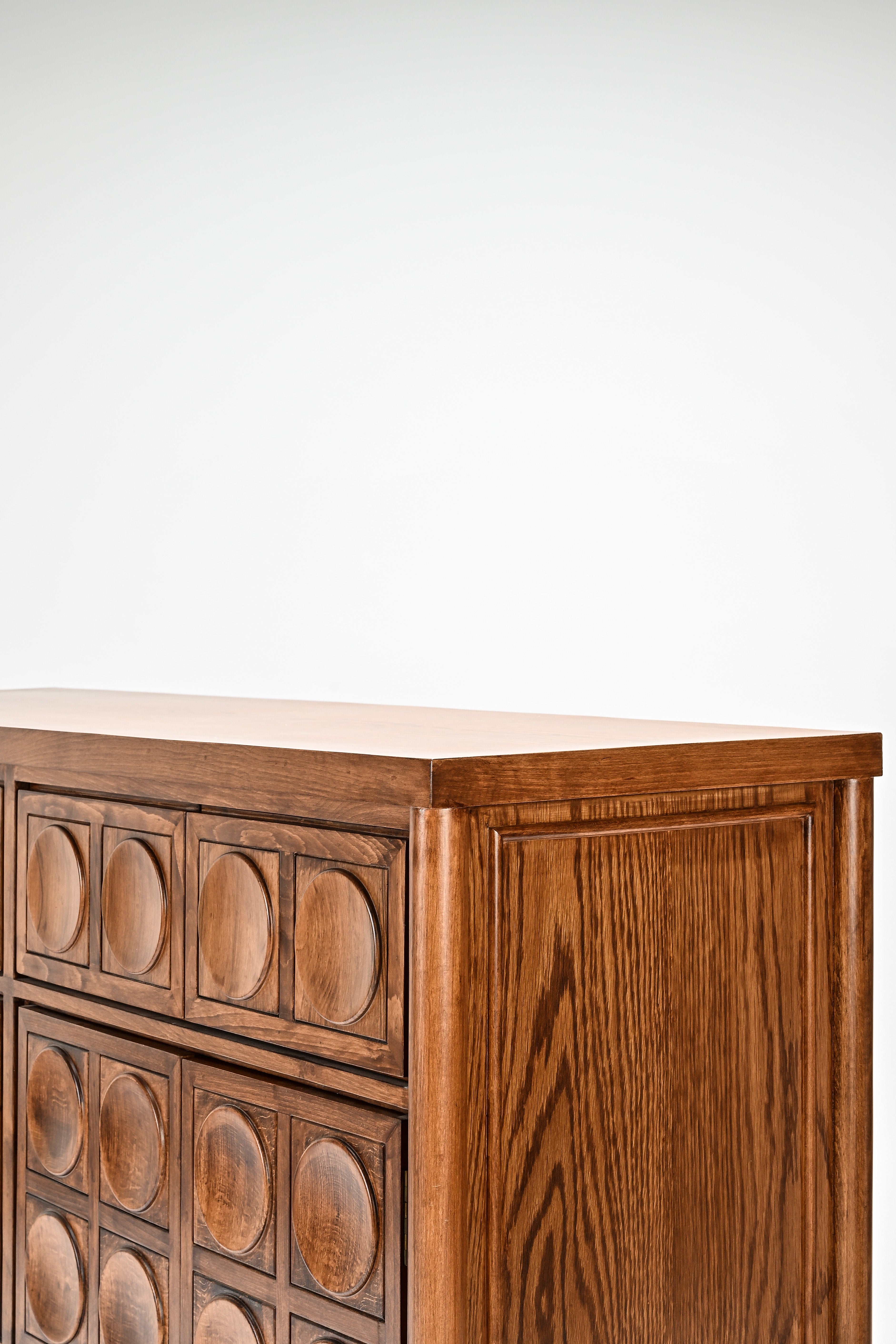 Wooden dresser with circular patterns on a white background