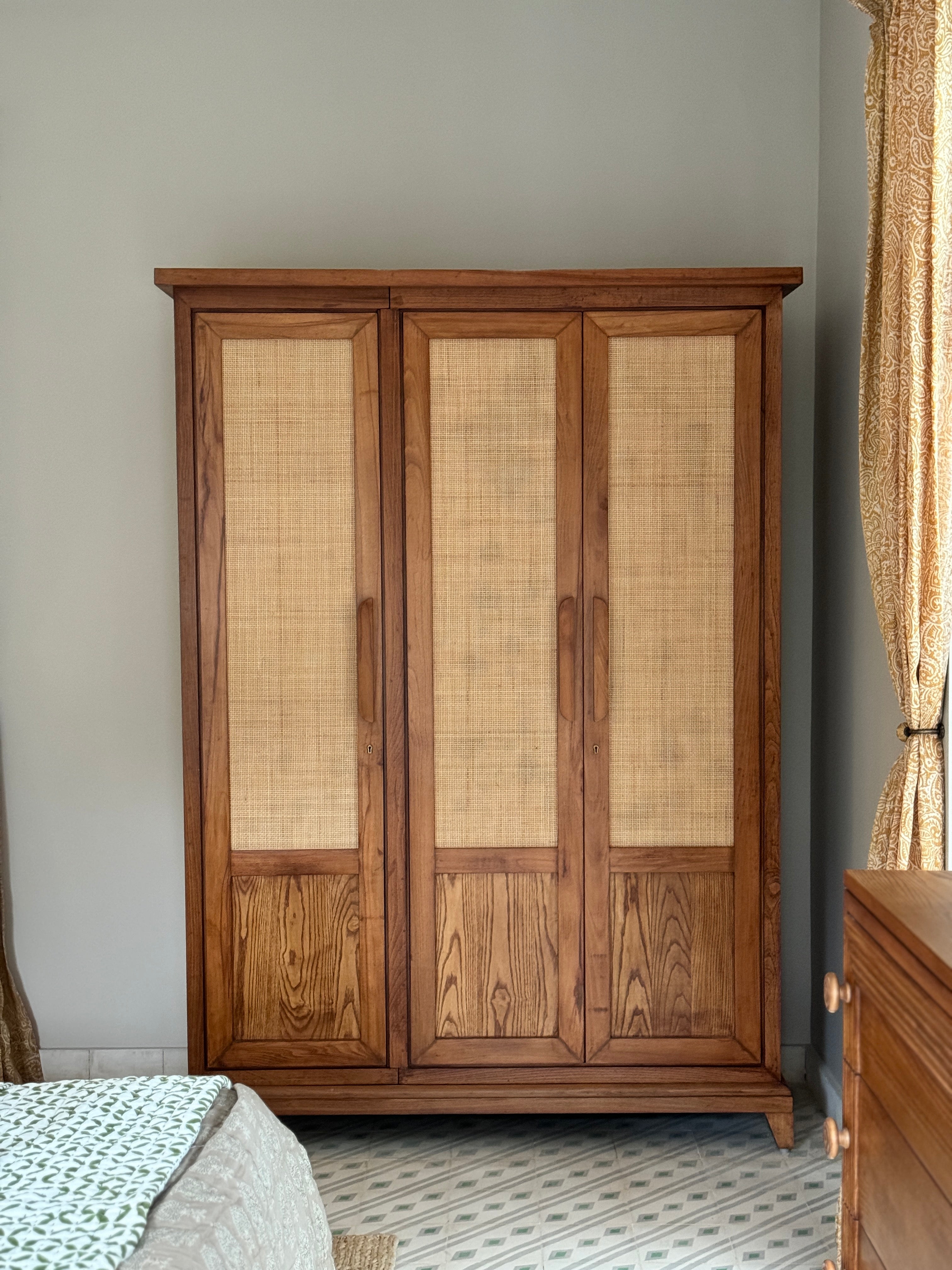 Wooden wardrobe with wicker doors in a room setting
