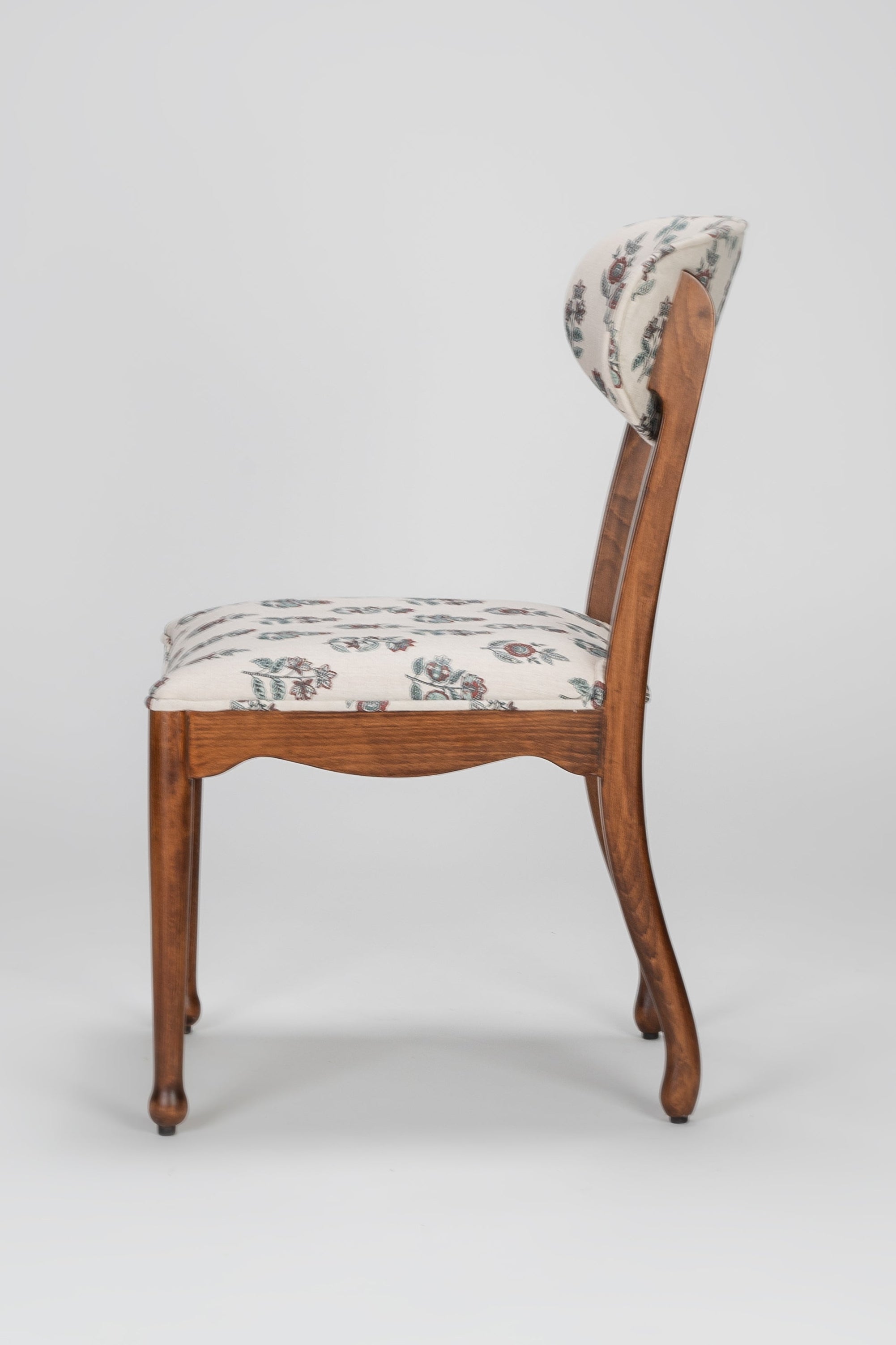 Wooden chair with patterned cushion on a gray background
