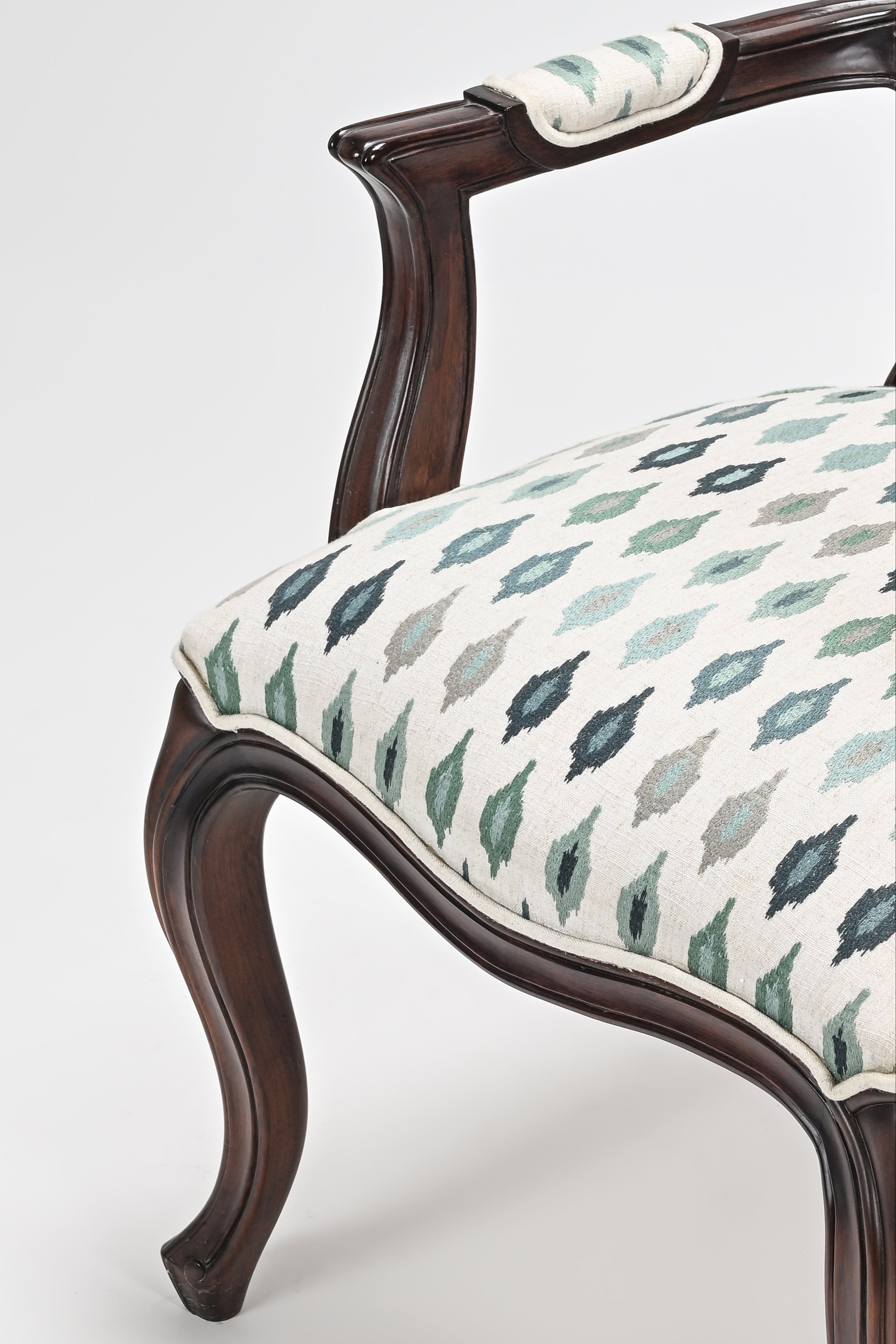 Chair with wooden frame and patterned fabric seat on a white background