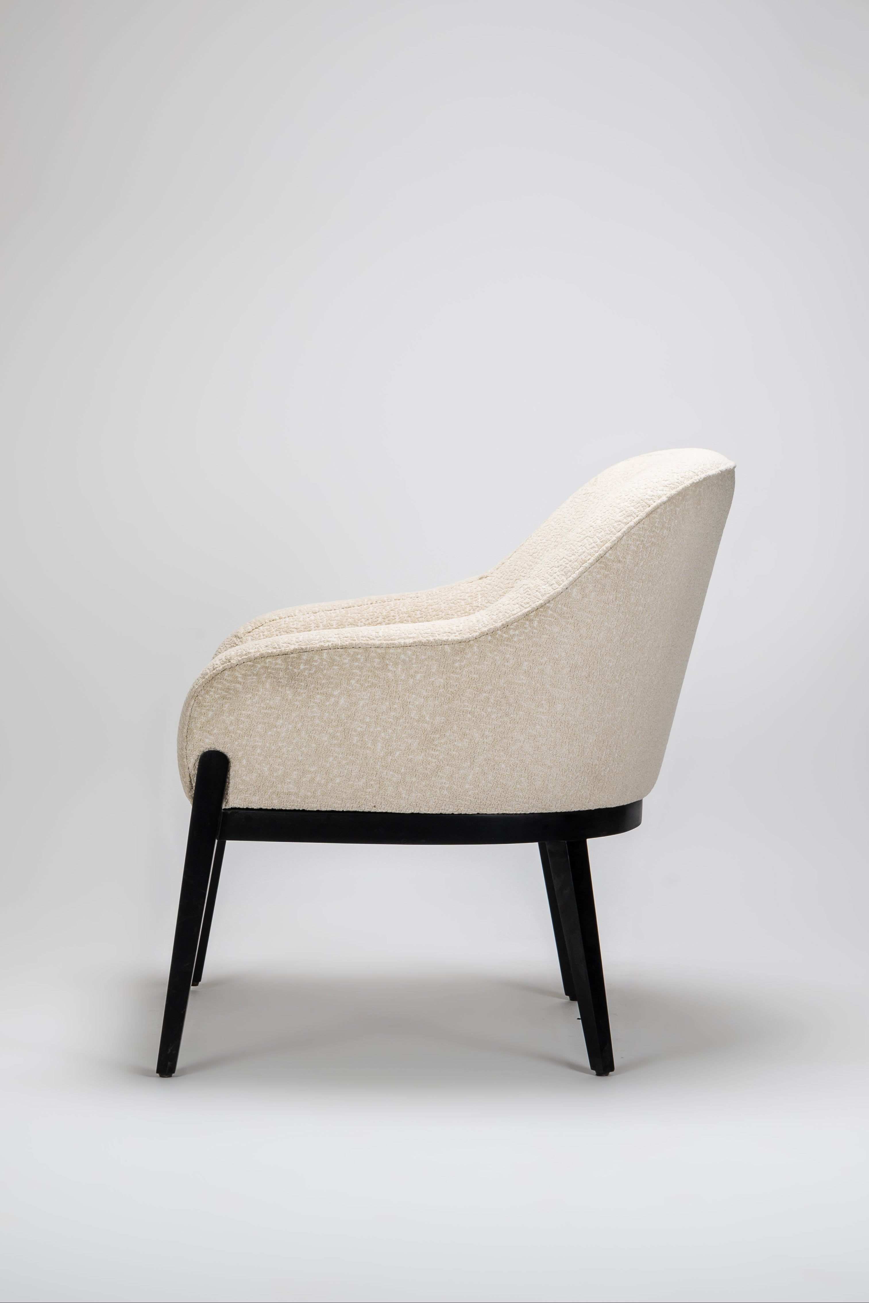 Beige armchair with black legs on a light gray background