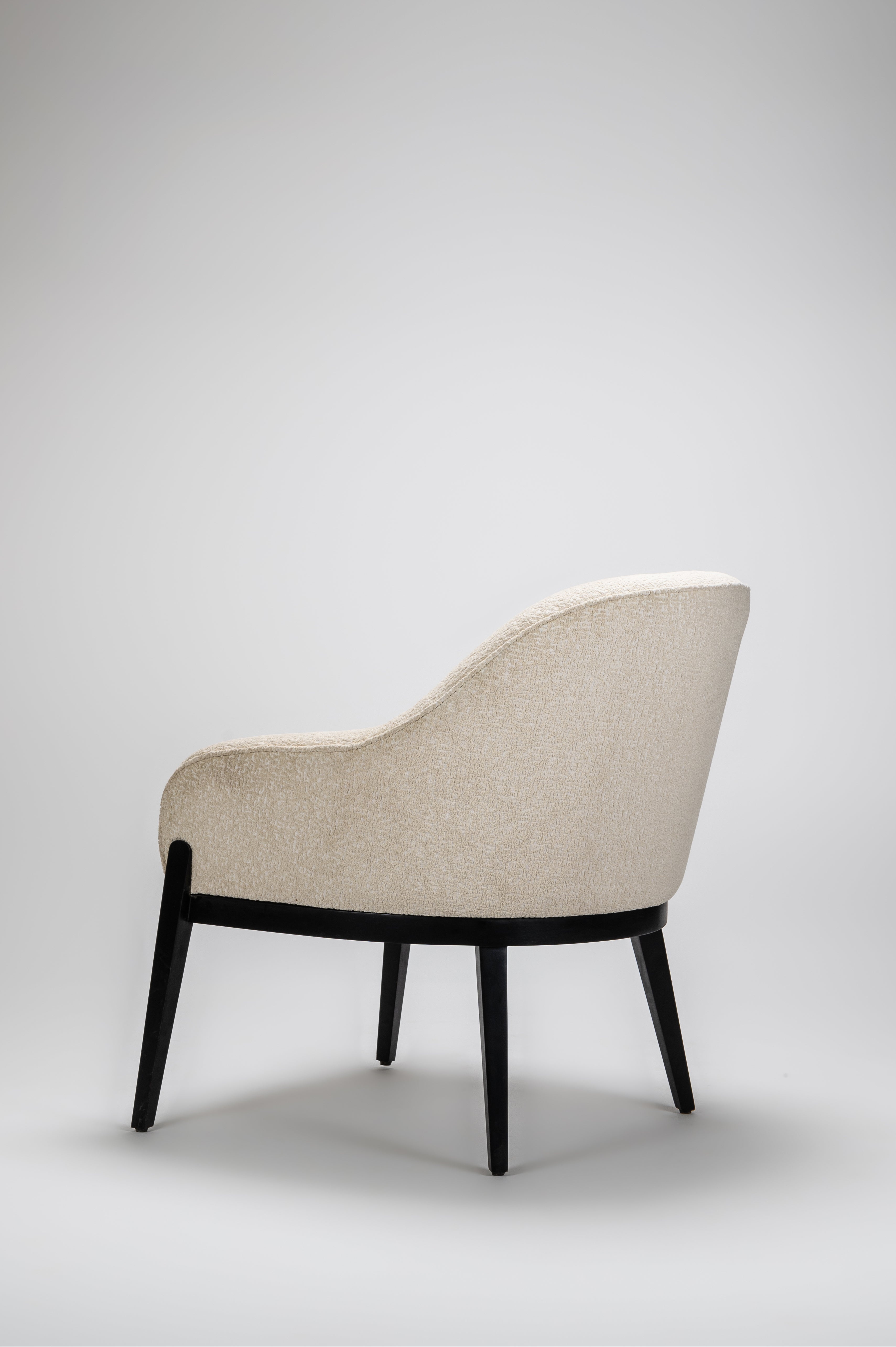 Beige armchair with black legs on a light gray background