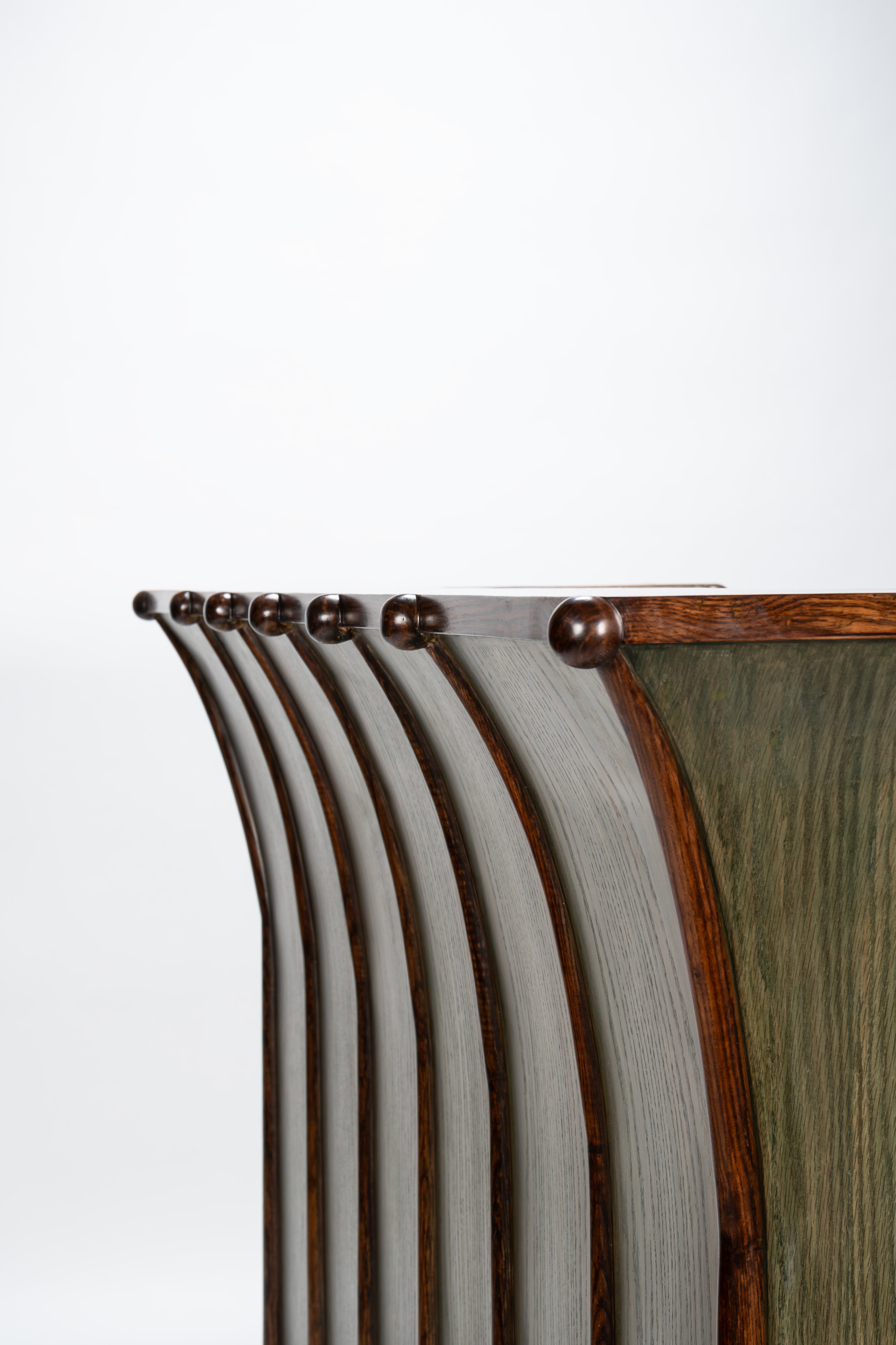 Wooden headboard with curved design and metal fixtures on a white background