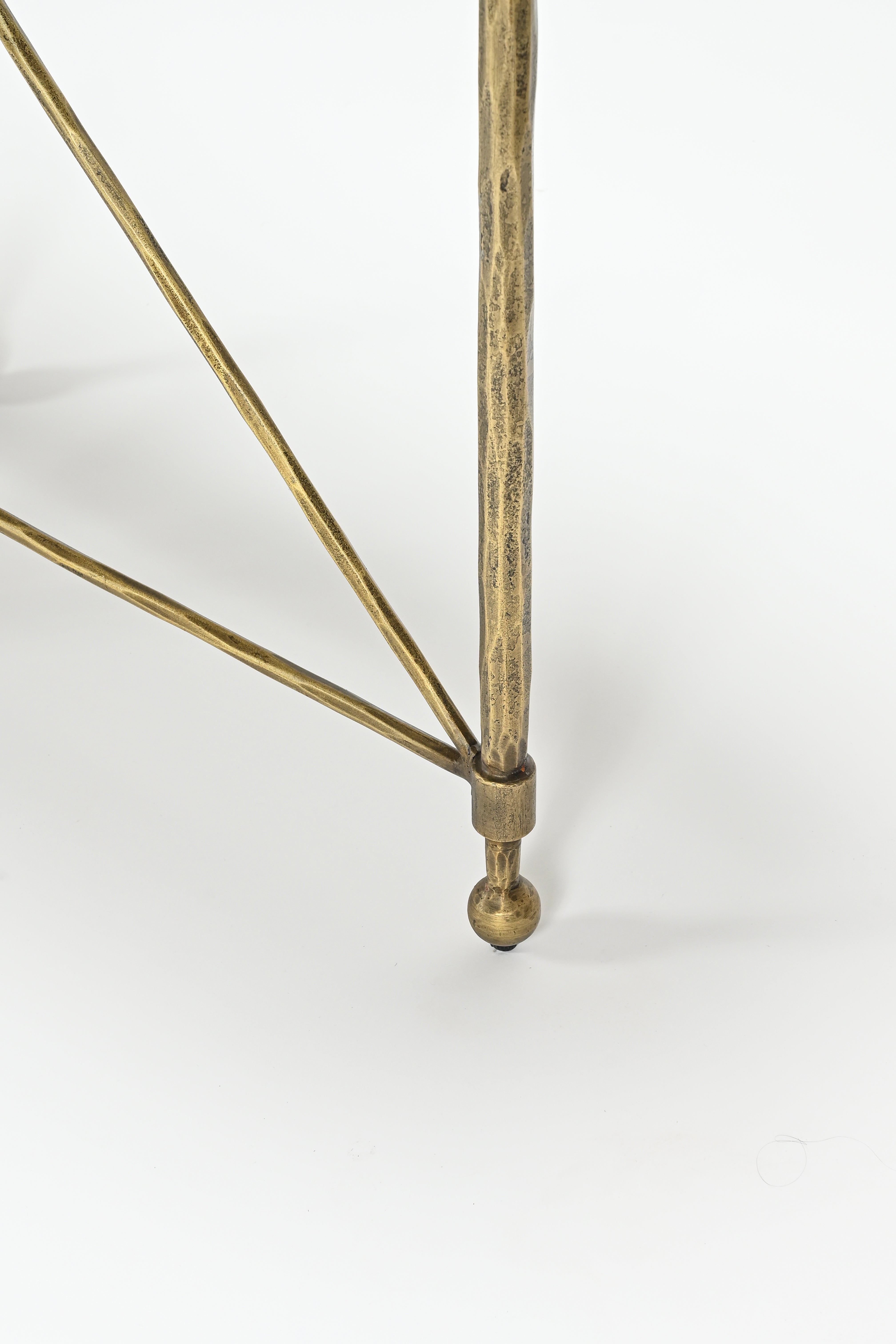 Close-up of a brass geometric floor lamp on a white background