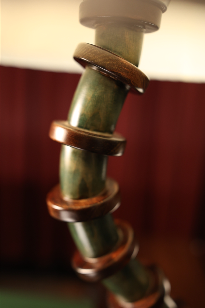 Close-up of a metal rod with threaded sections against a blurred background