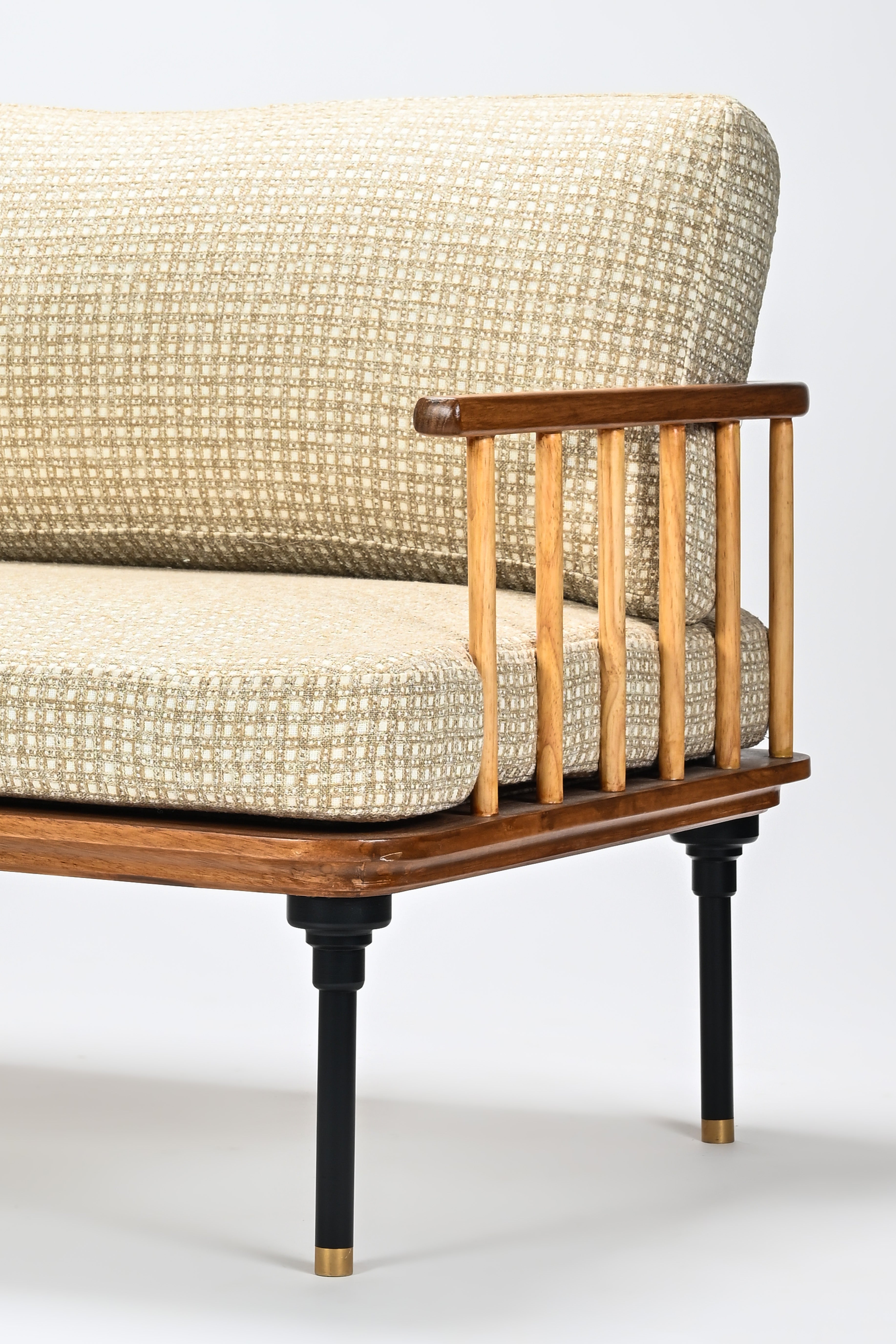 Beige upholstered chair with wooden frame and black legs on a white background