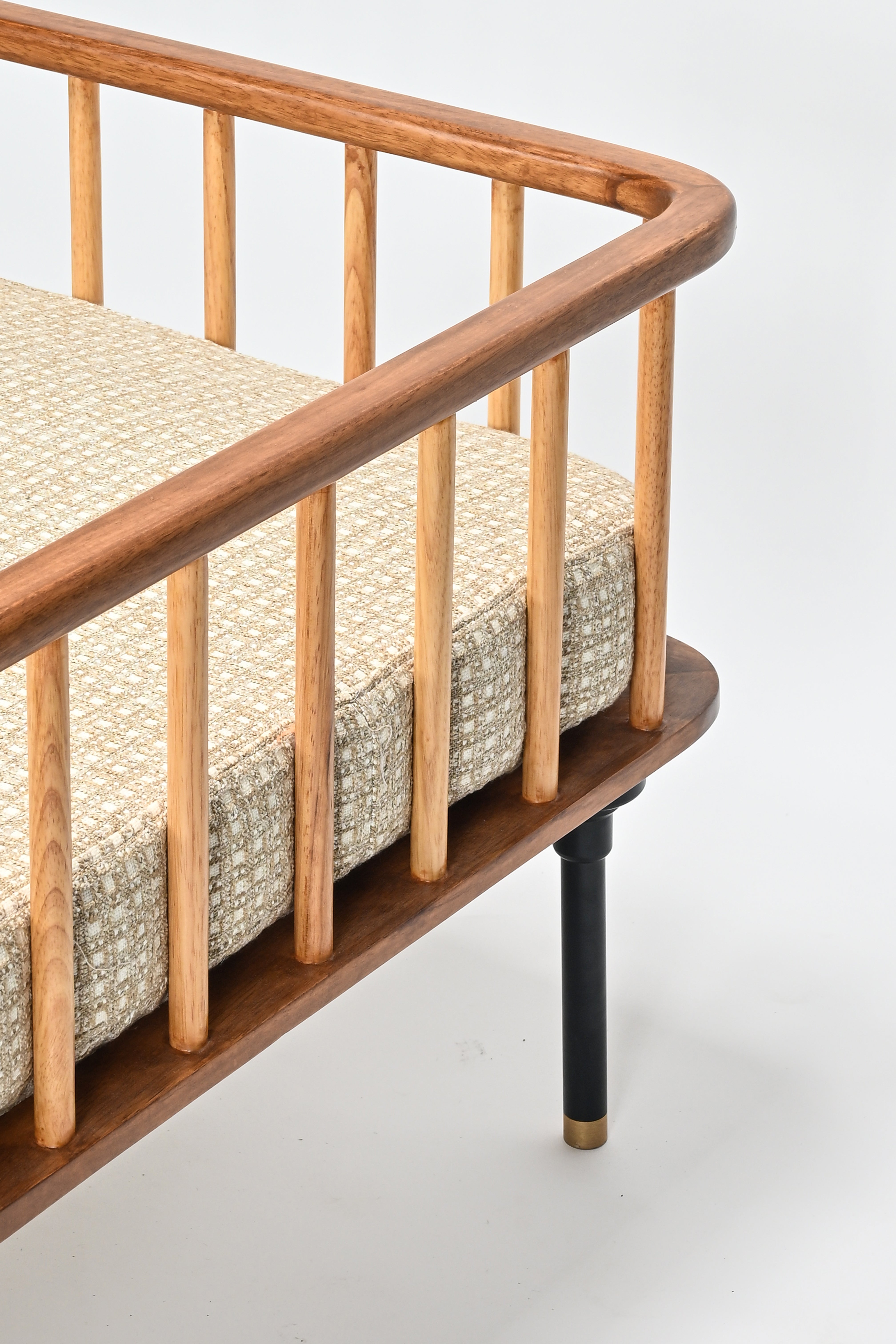 Wooden bench with a textured cushion on a light gray background