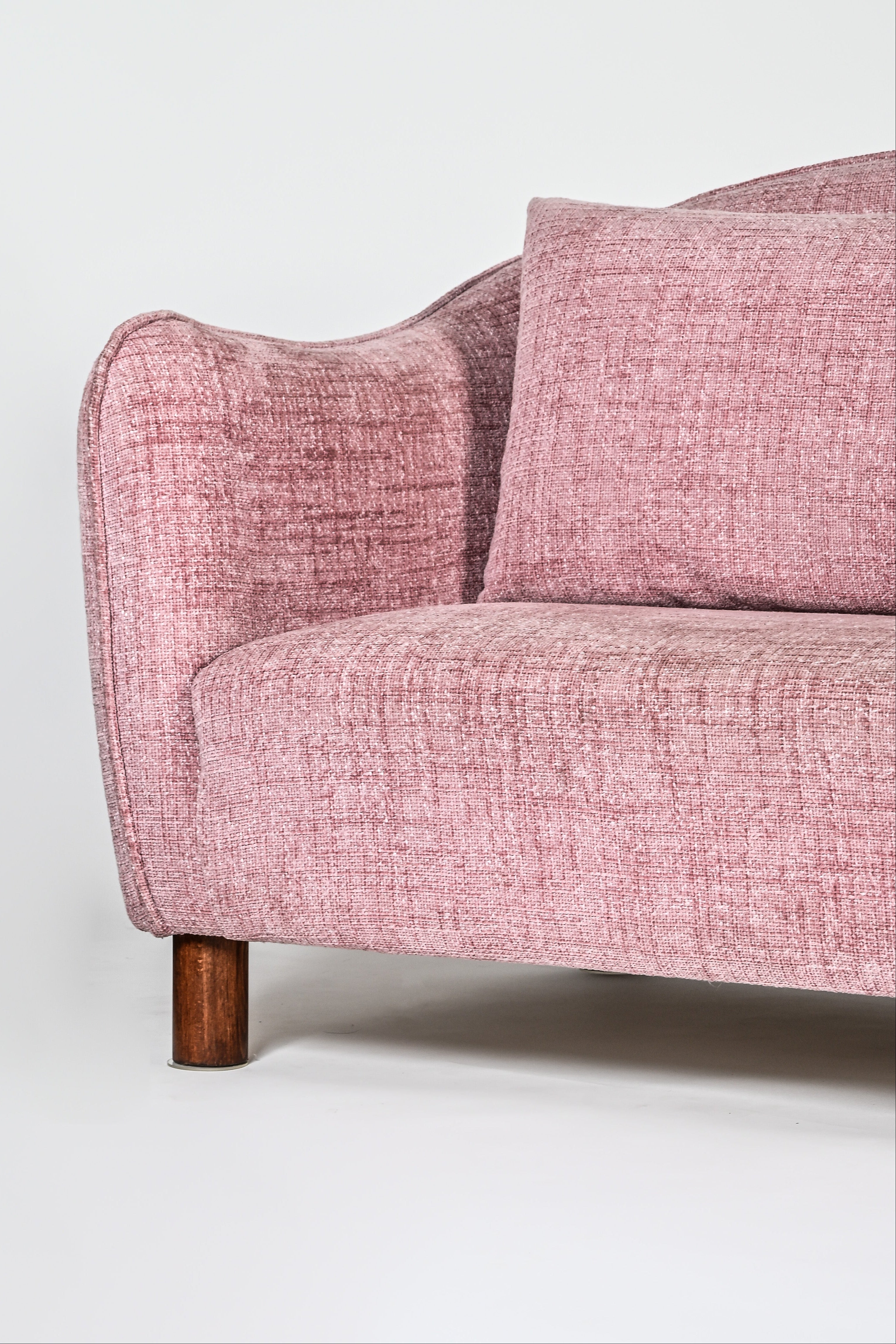 Pink sofa with wooden legs on a white background