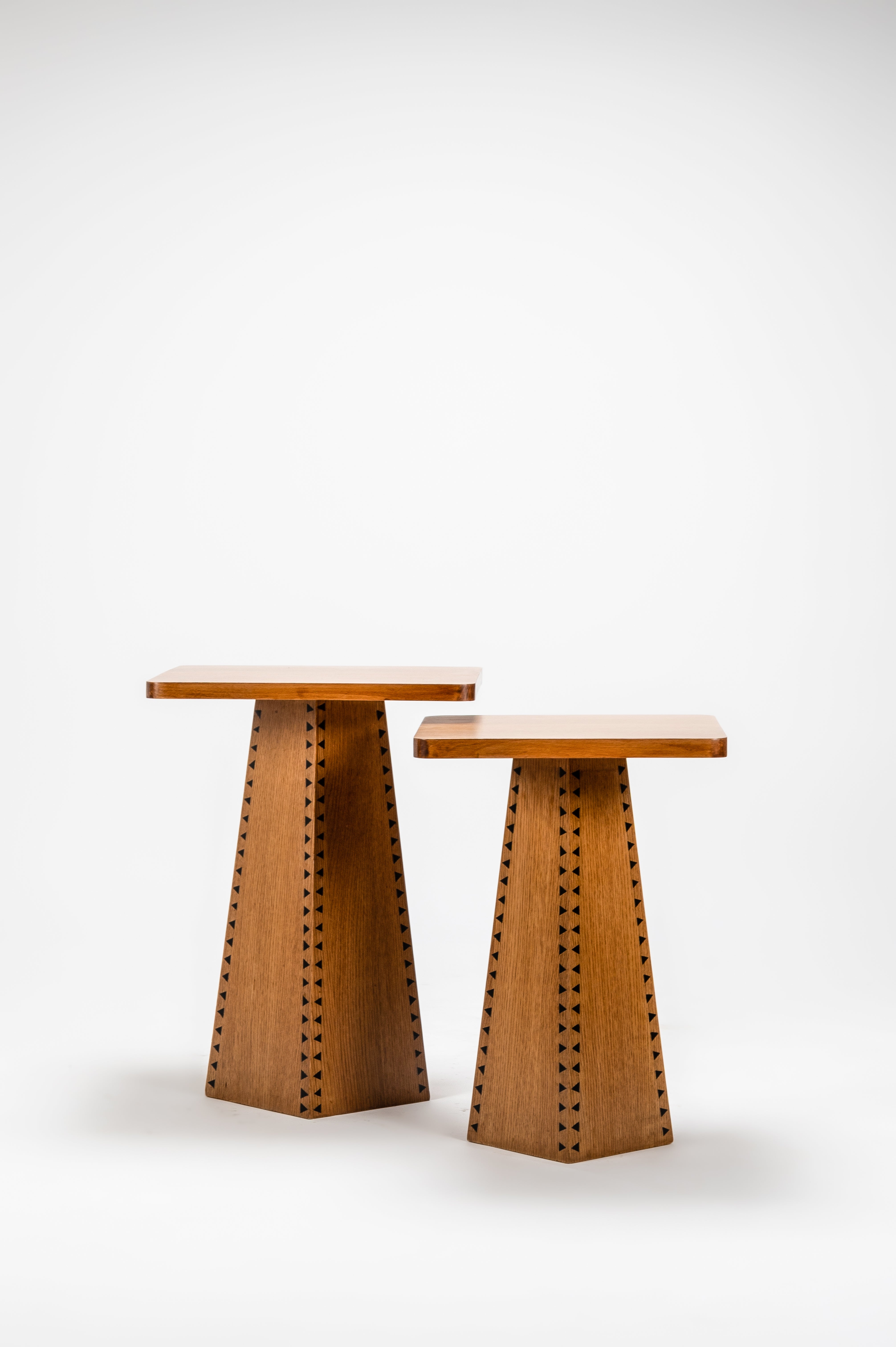 Two wooden stools with a geometric design on a white background