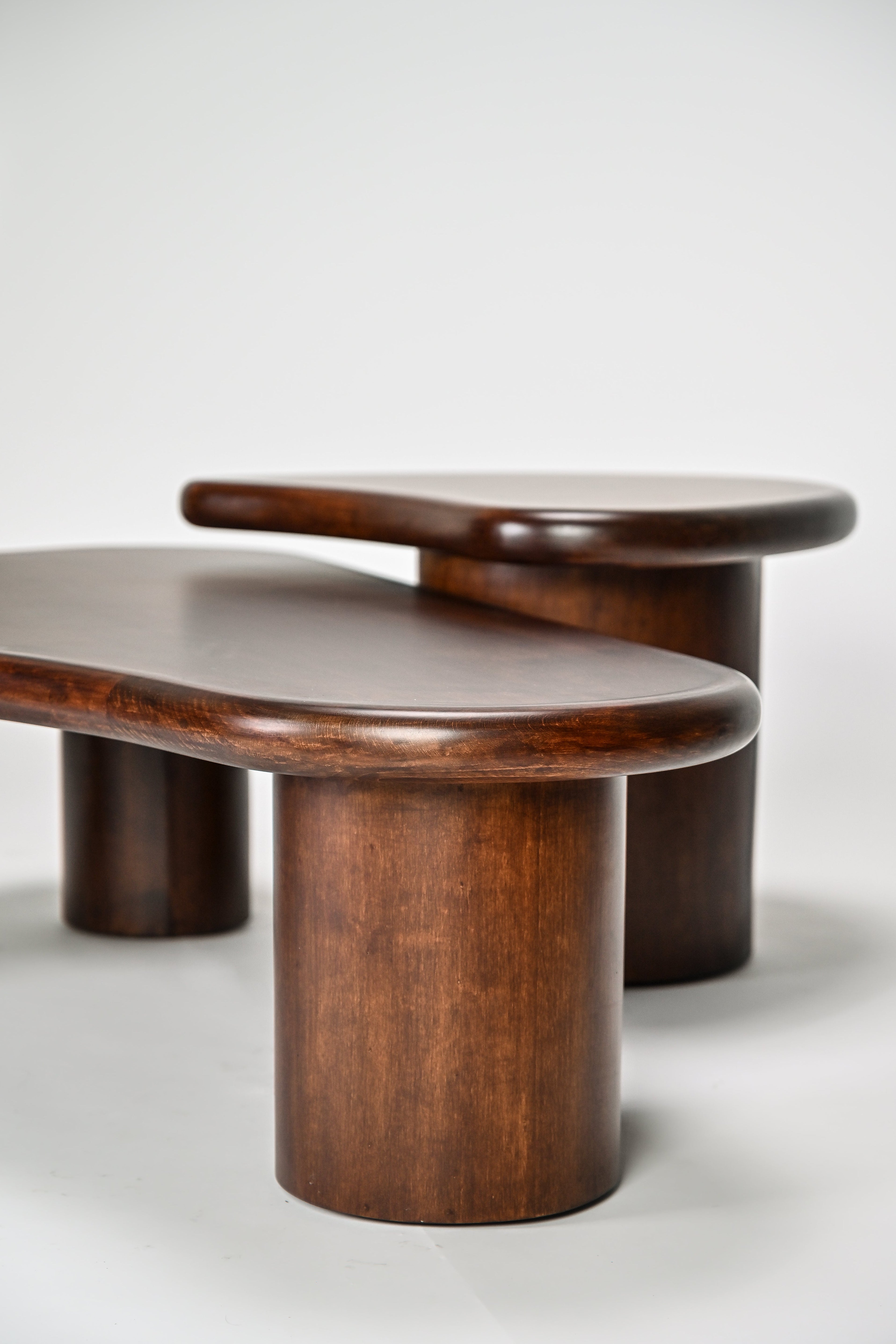 Three wooden tables with a modern design on a white background