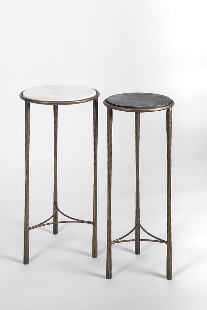 Two small round tables with marble tops on a white background