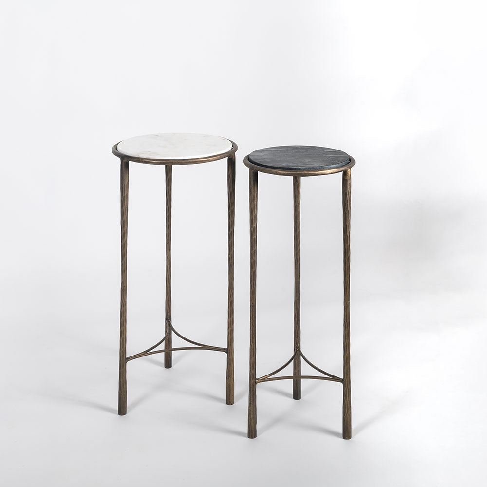 Two small round tables with marble tops on a white background