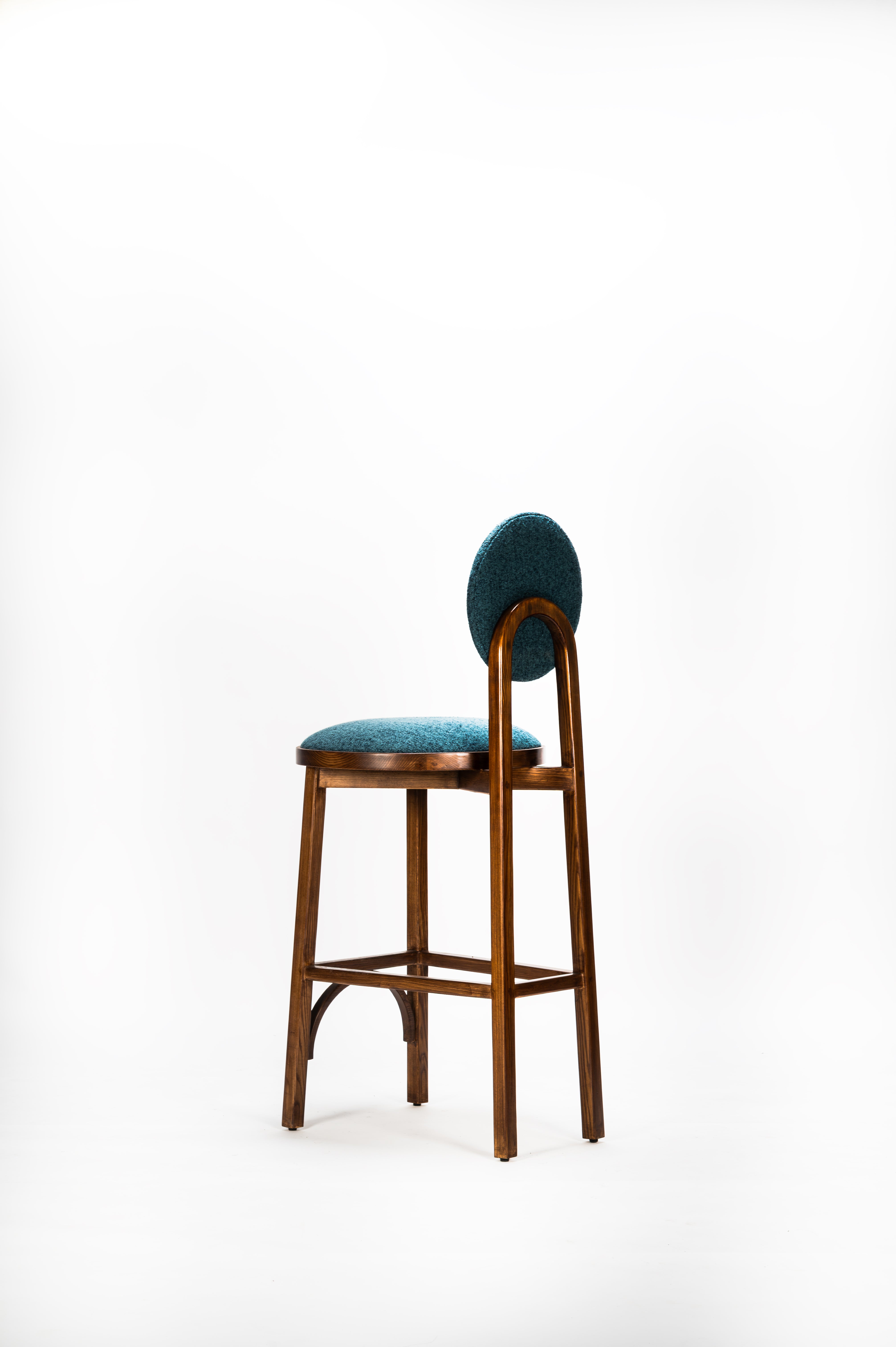 Bar stool with teal cushioned seat and backrest on a white background