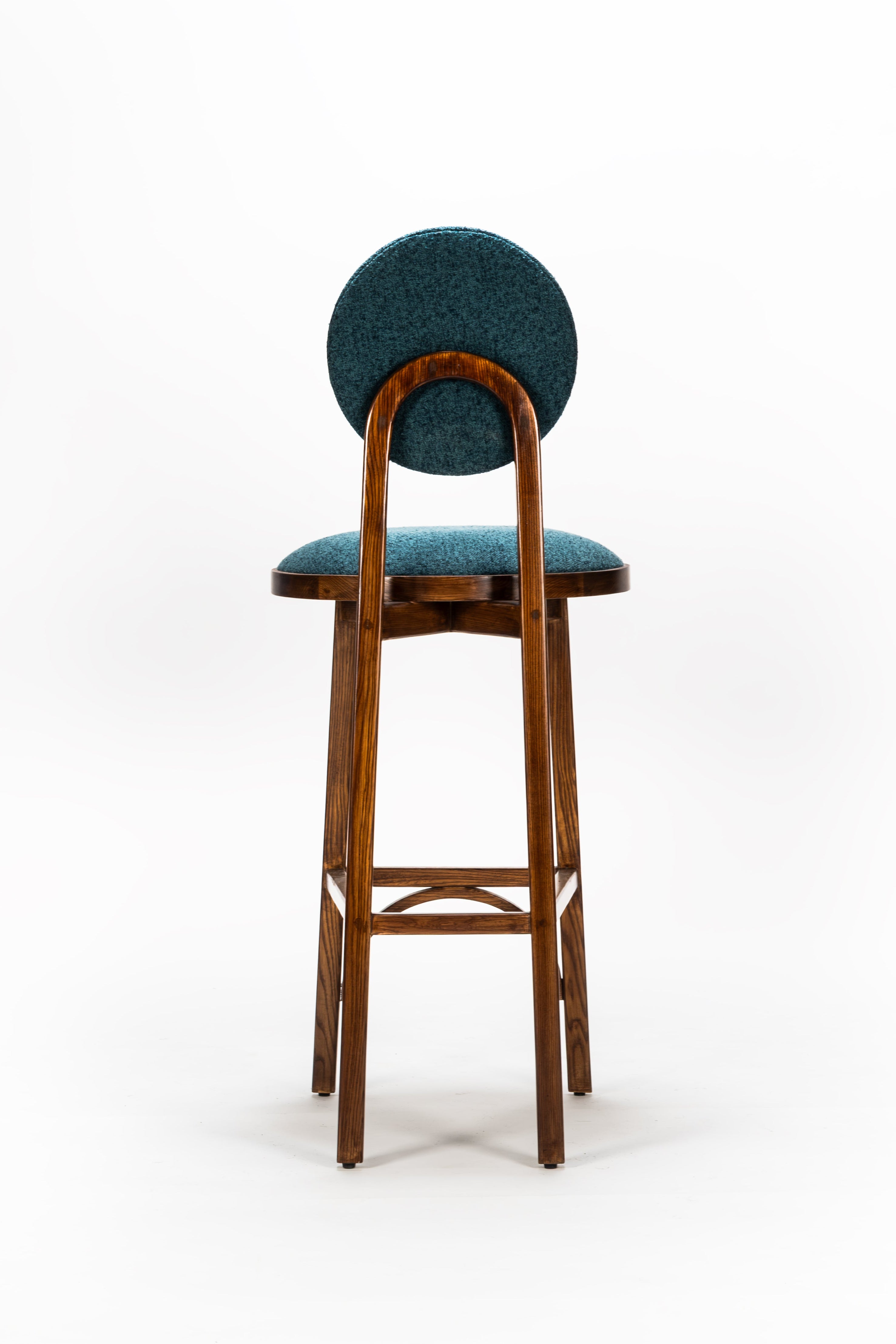 Bar stool with a green cushioned seat and backrest on a white background
