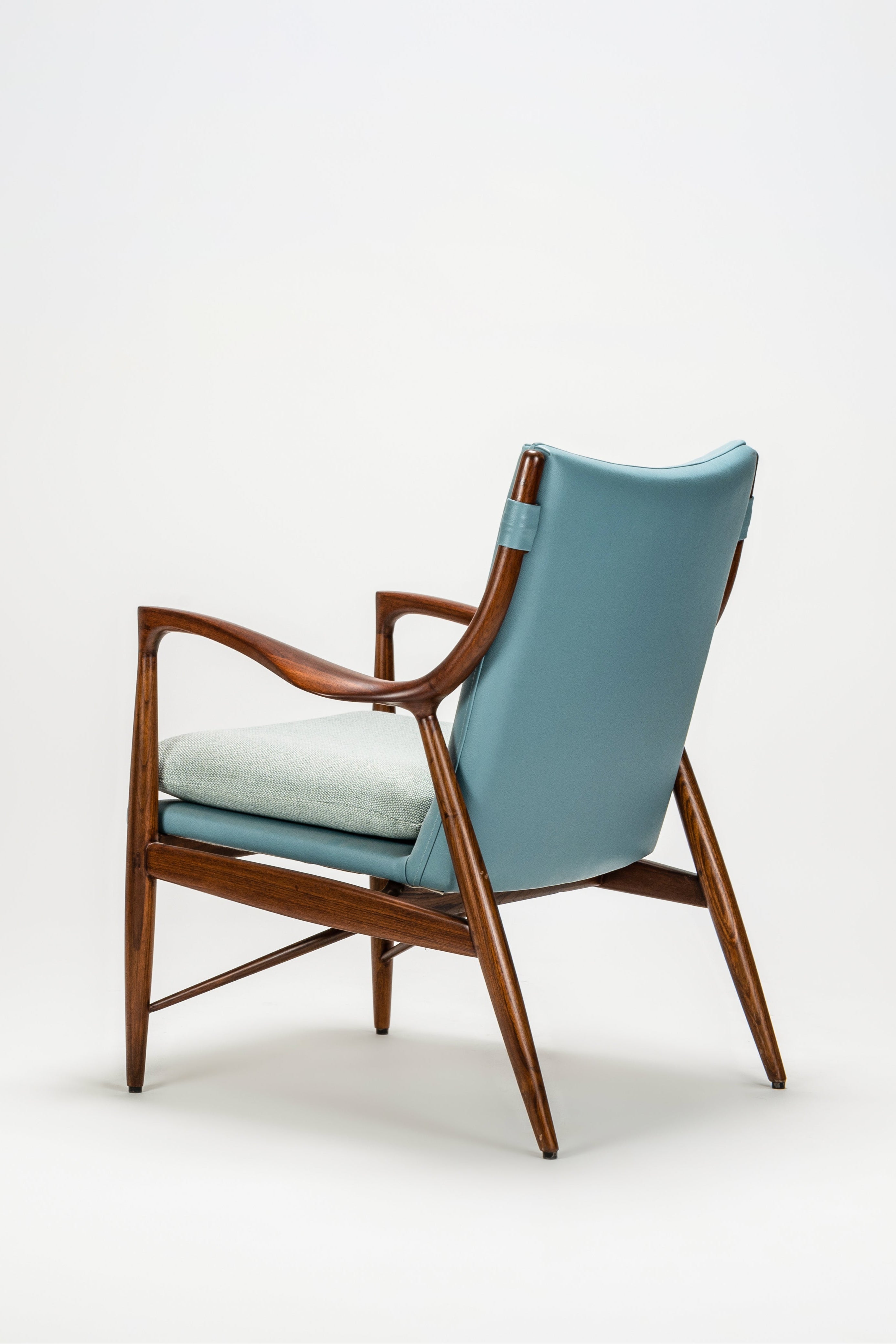 Chair with blue cushion and wooden frame on a white background