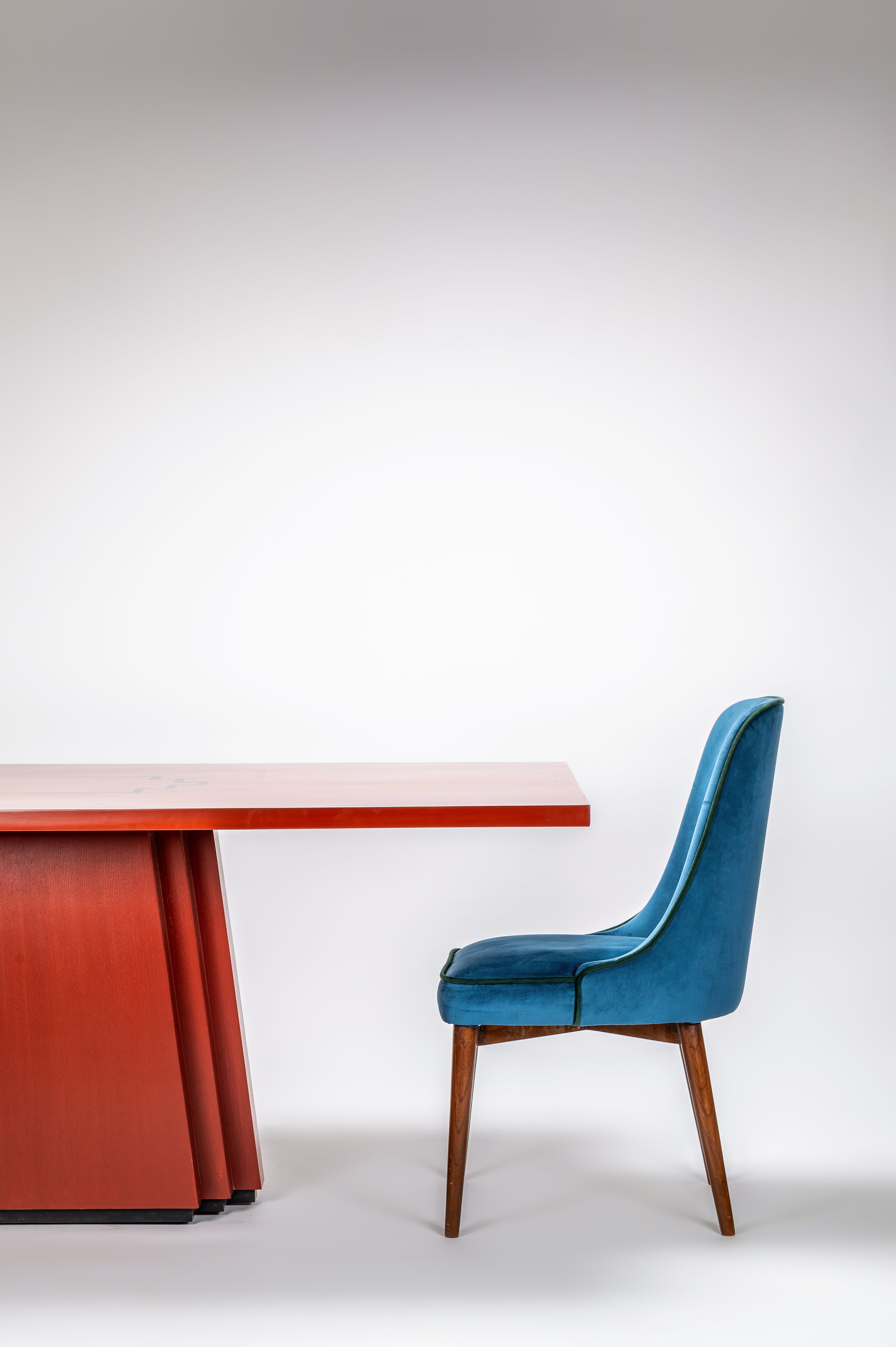 Blue chair in front of a red table on a white background