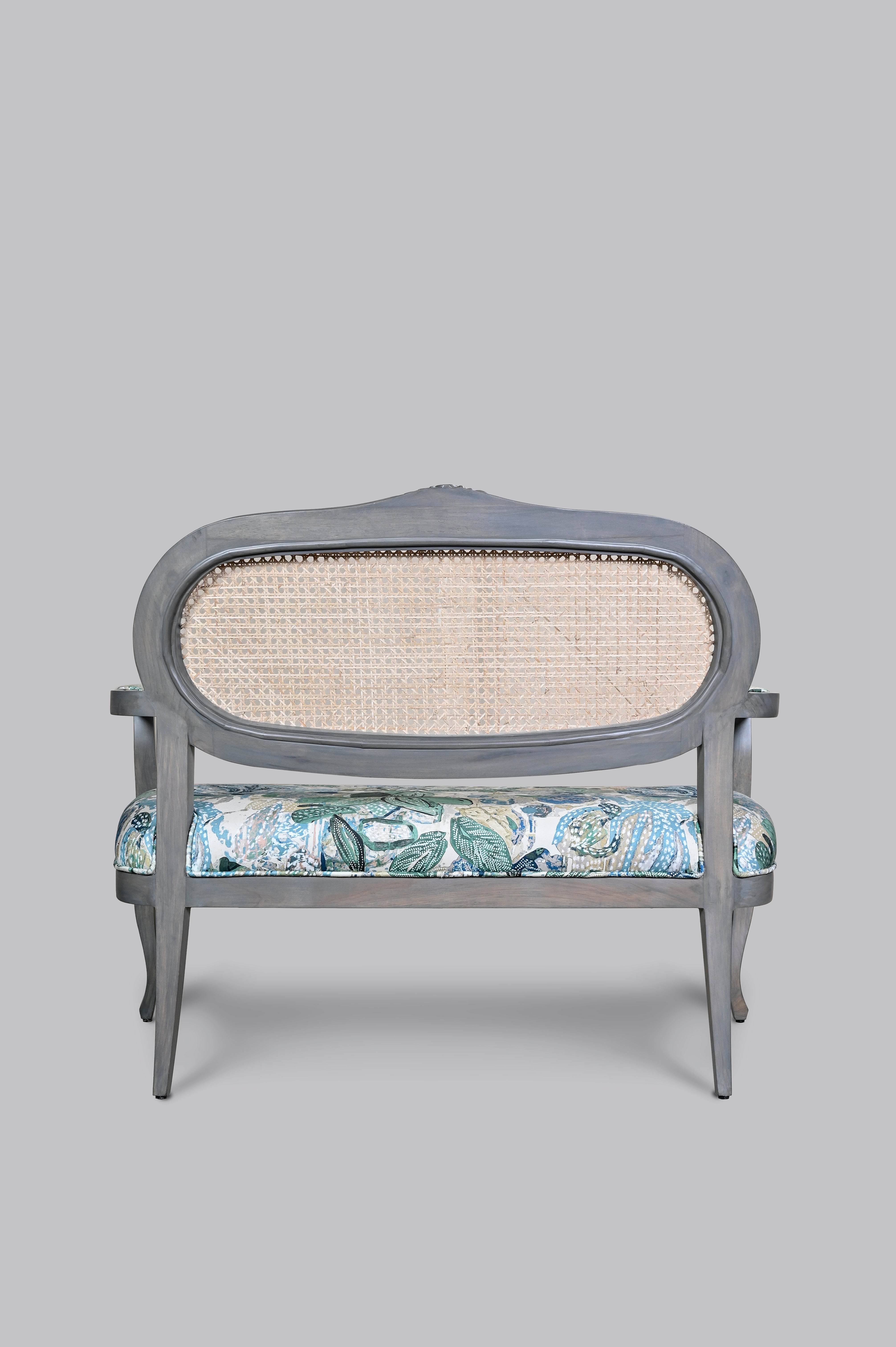 Gray armchair with floral-patterned cushion on a gray background