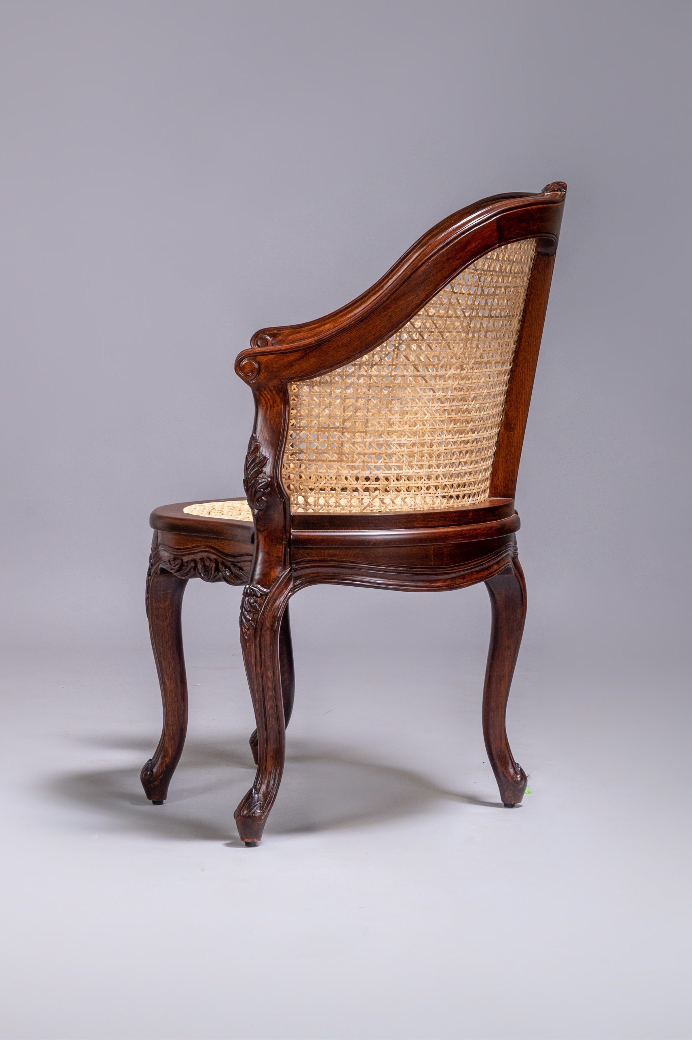 Wooden chair with wicker backrest on a gray background