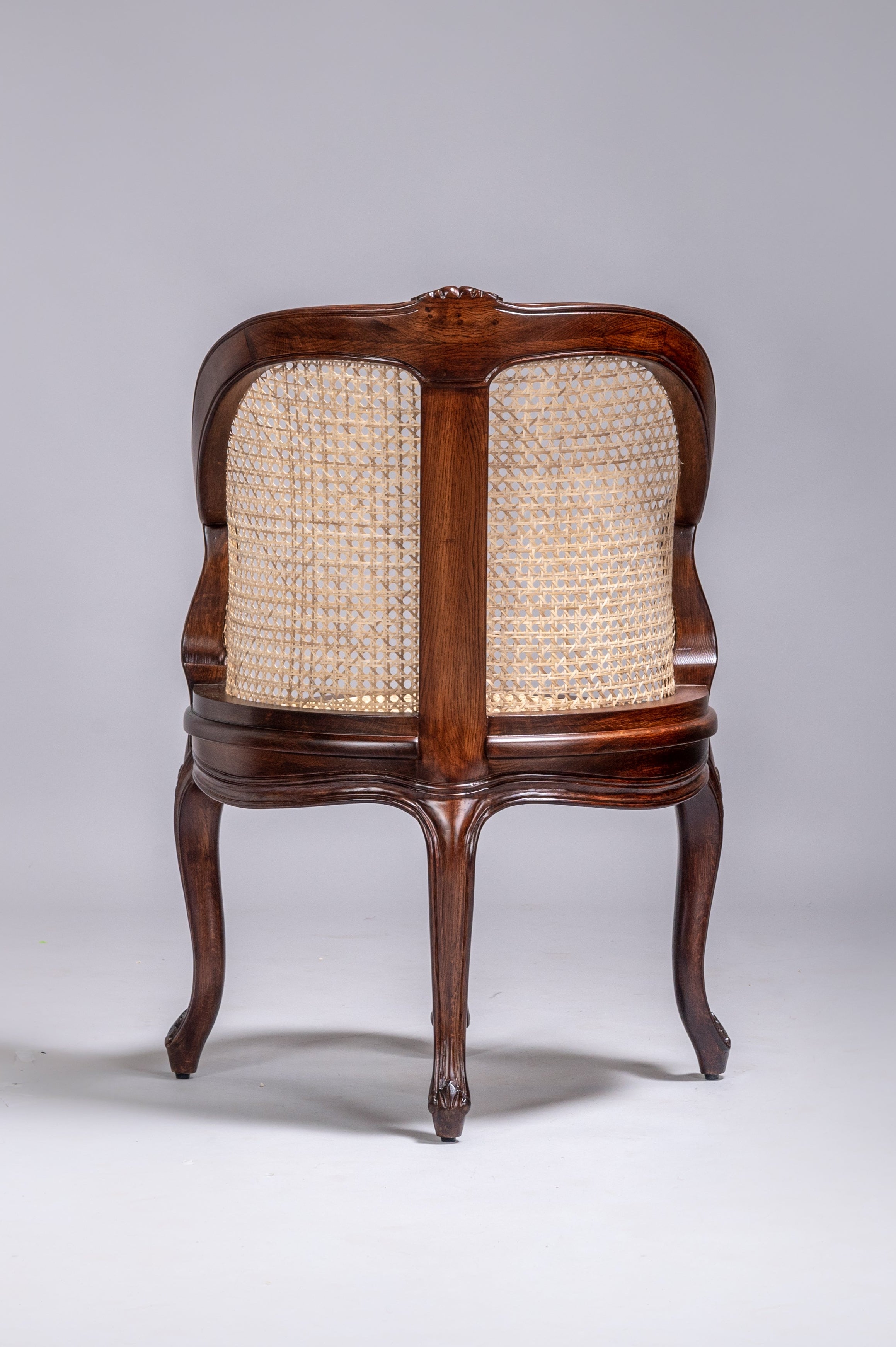 Wooden chair with wicker backrest on a gray background