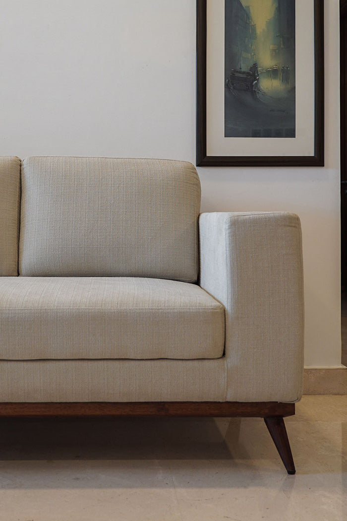 Beige sofa in a room with a painting on the wall