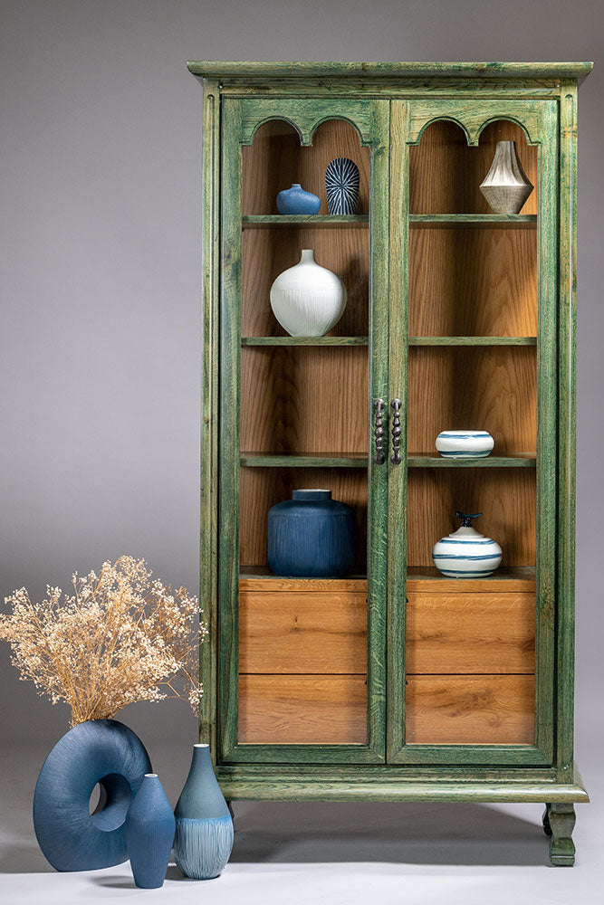 Wooden cabinet with green accents and decorative items on a gray background