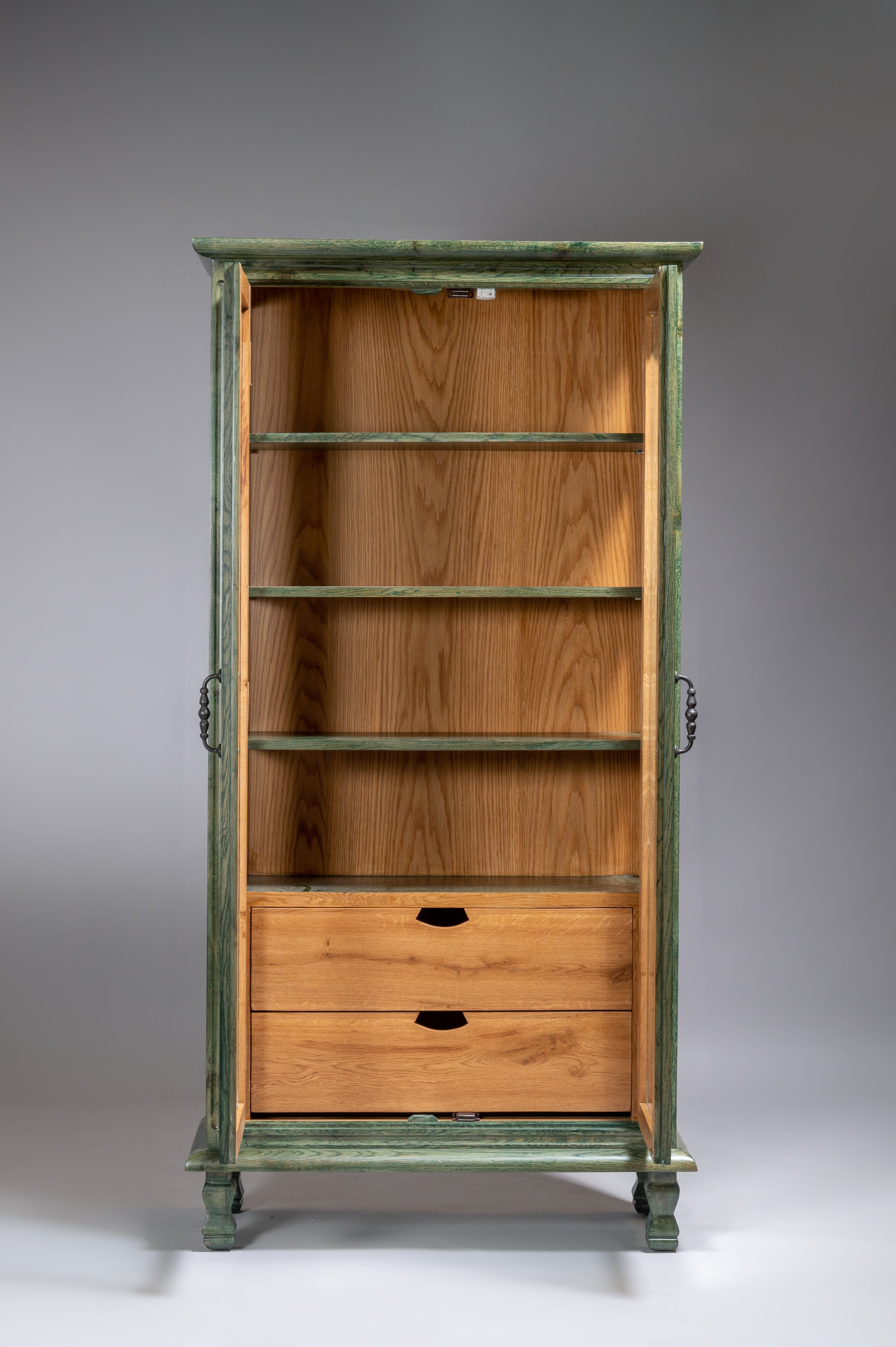 Wooden cabinet with green painted frame on a gray background