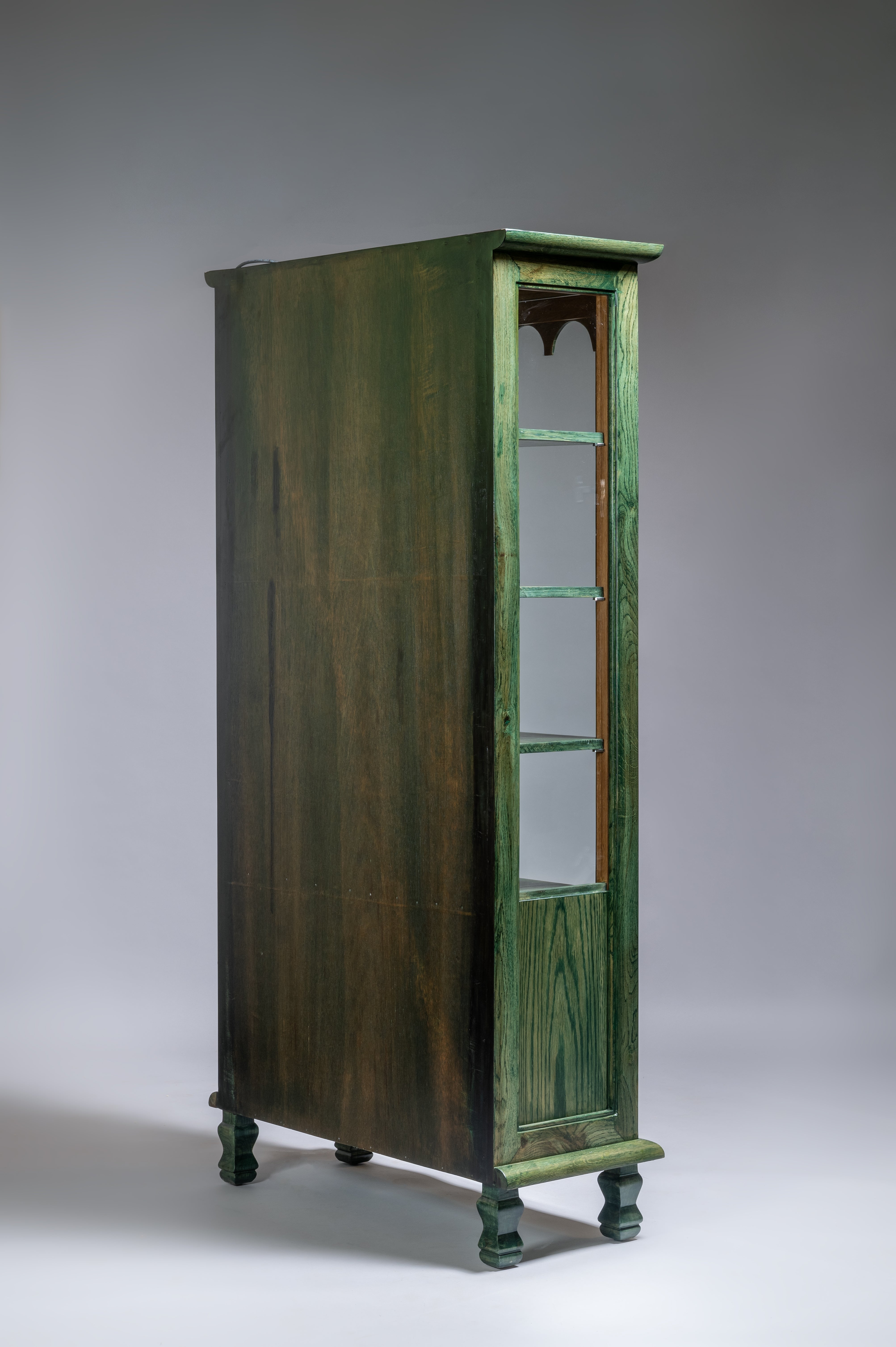Tall green cabinet with glass doors on a gray background