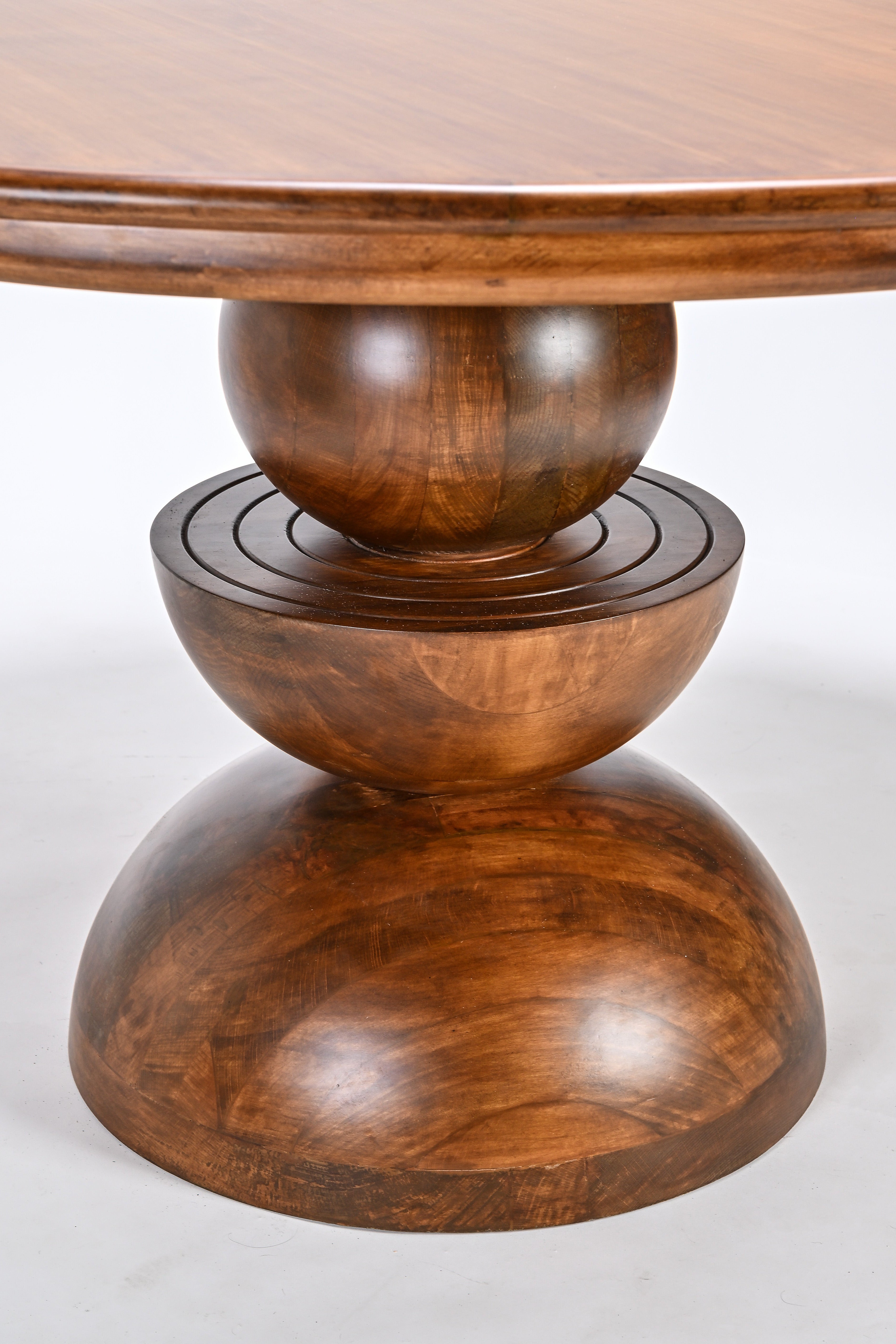 Wooden table with a round top and tiered base on a white background