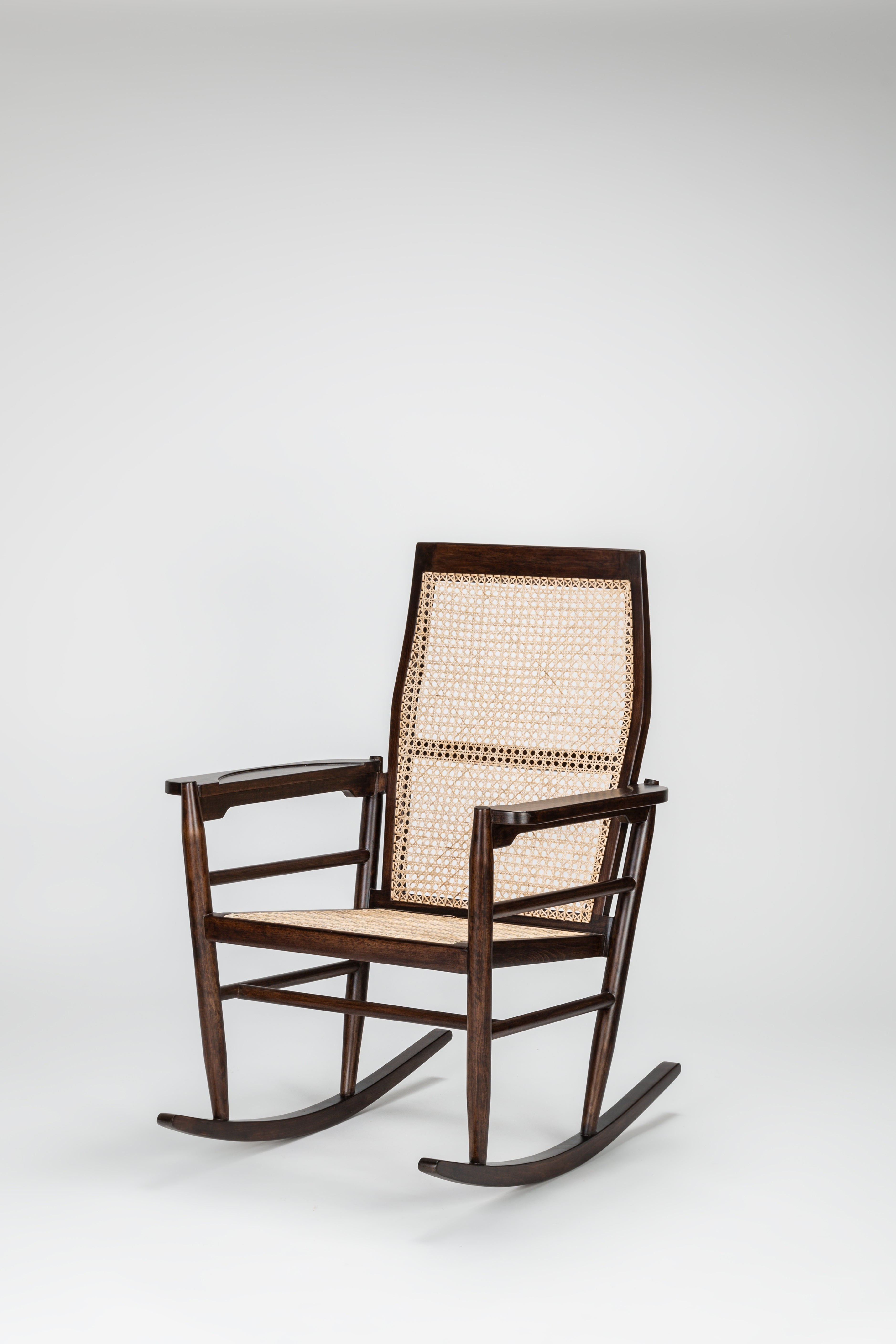 Wooden rocking chair with wicker backrest on a white background
