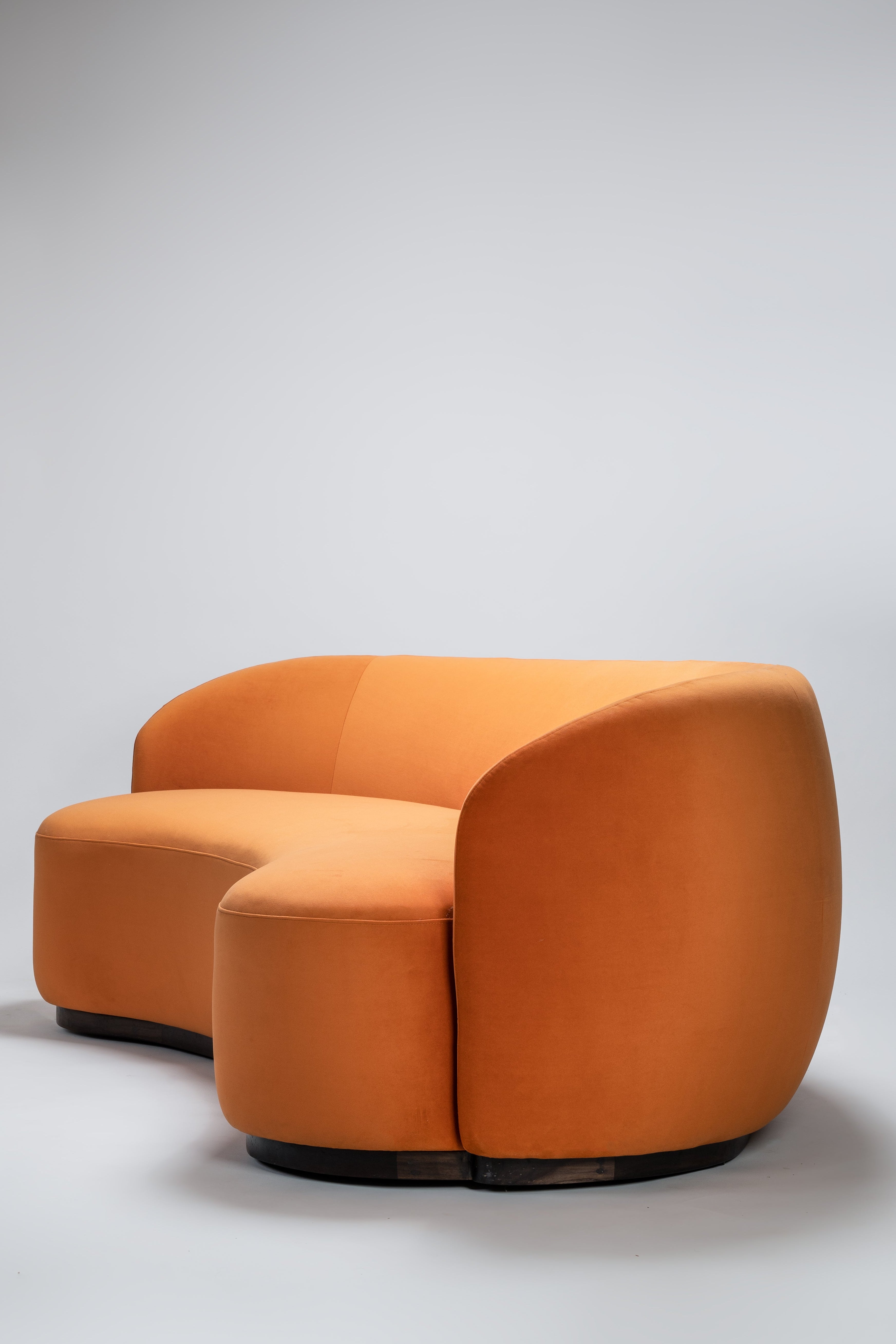 Orange sofa with matching ottoman on a light gray background