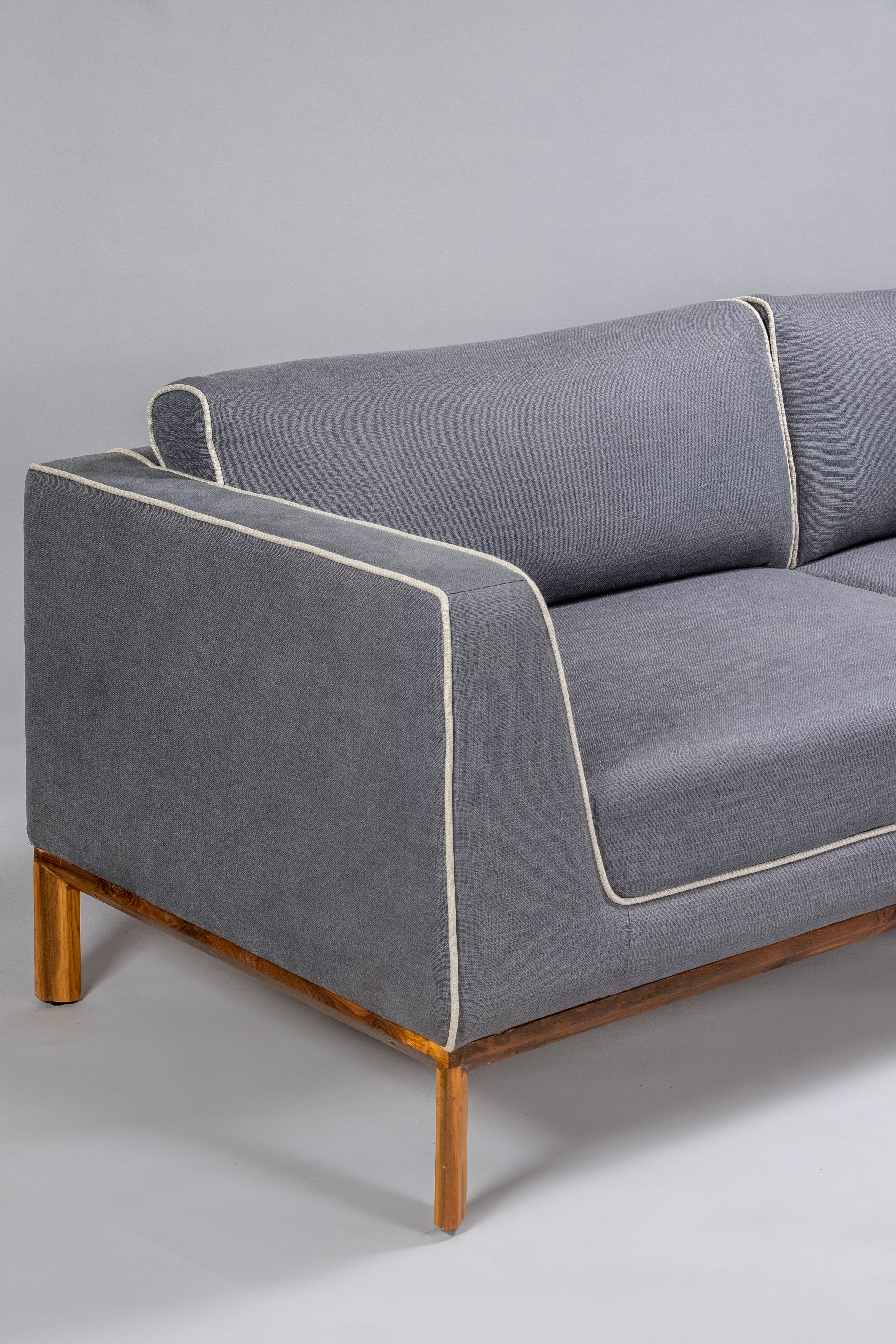 Gray sofa with wooden legs on a plain background