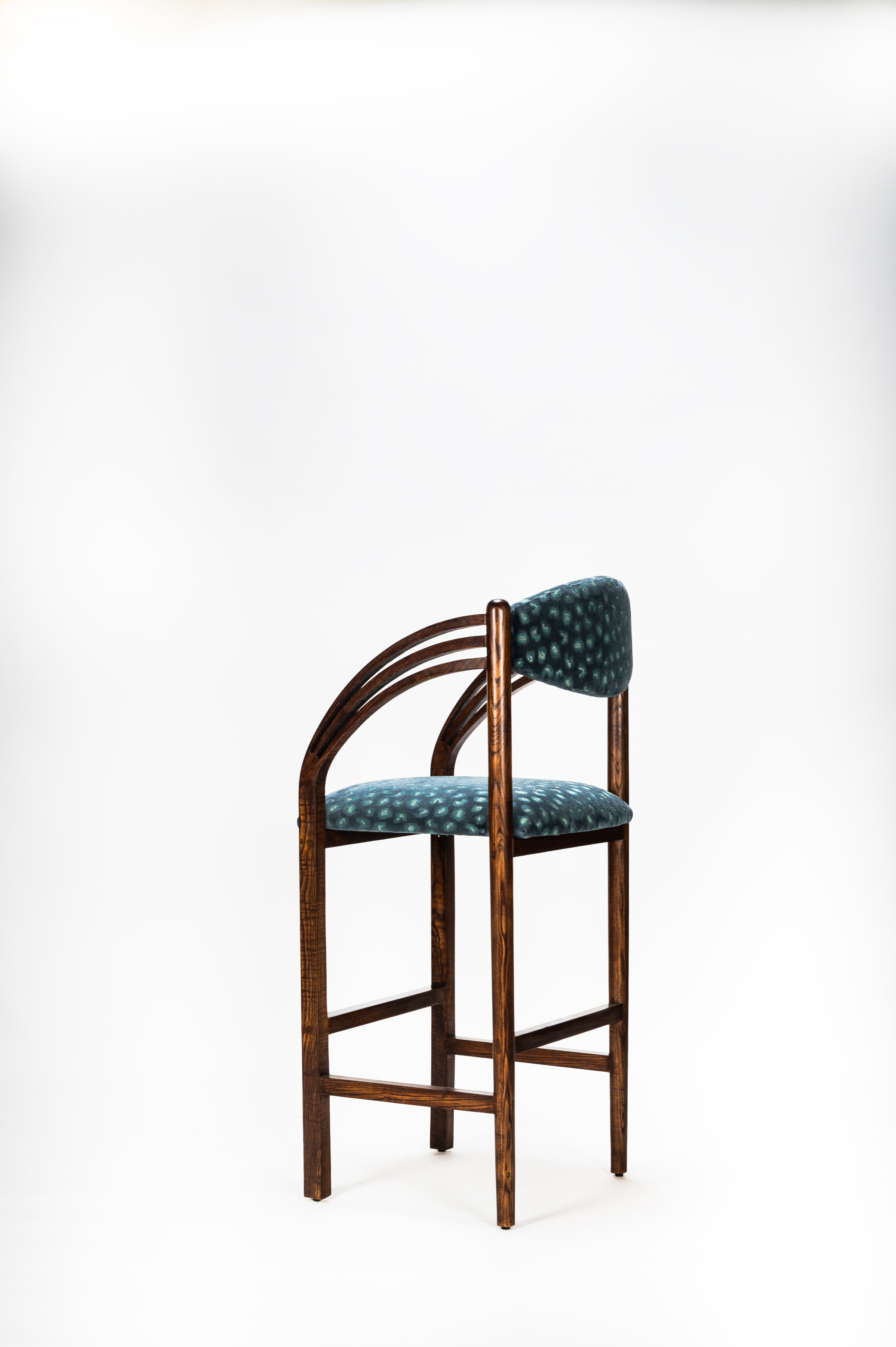 Wooden bar stool with patterned cushion on a white background