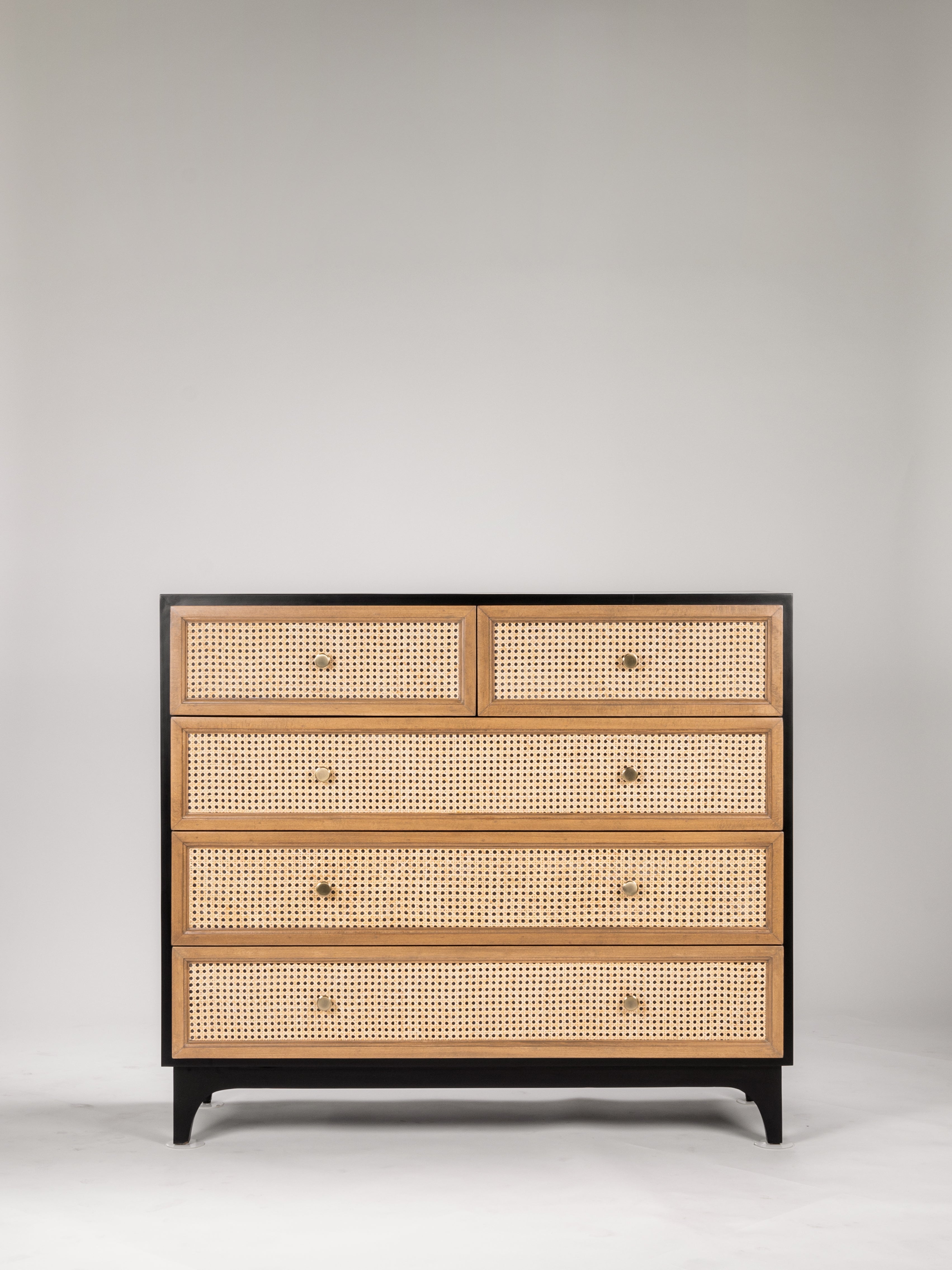 Wooden dresser with cane-style drawers on a gray background