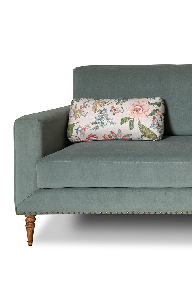 Green sofa with a floral pillow on a white background